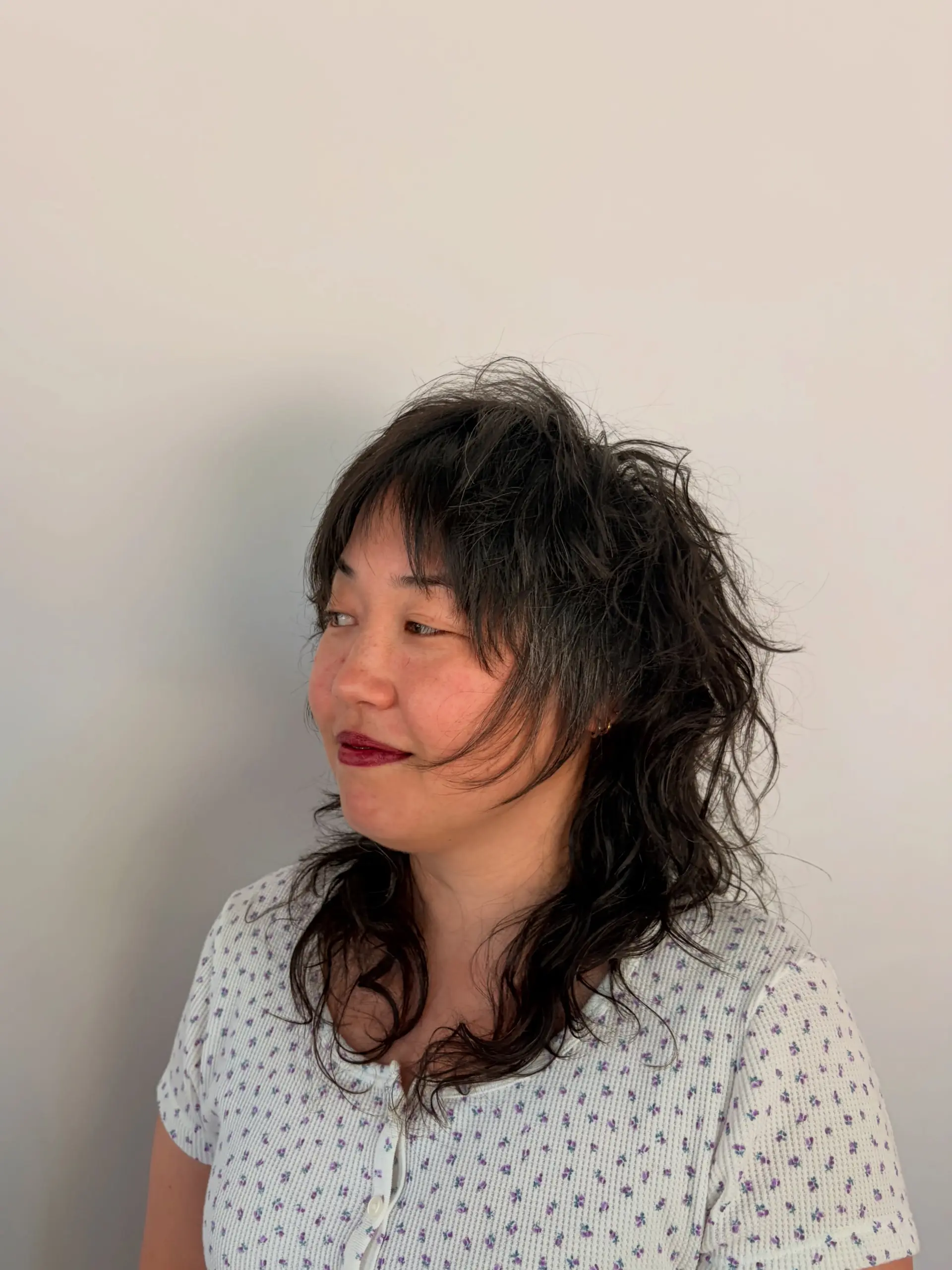 A textured medium-length shag haircut with natural waves and piecey bangs. 1
