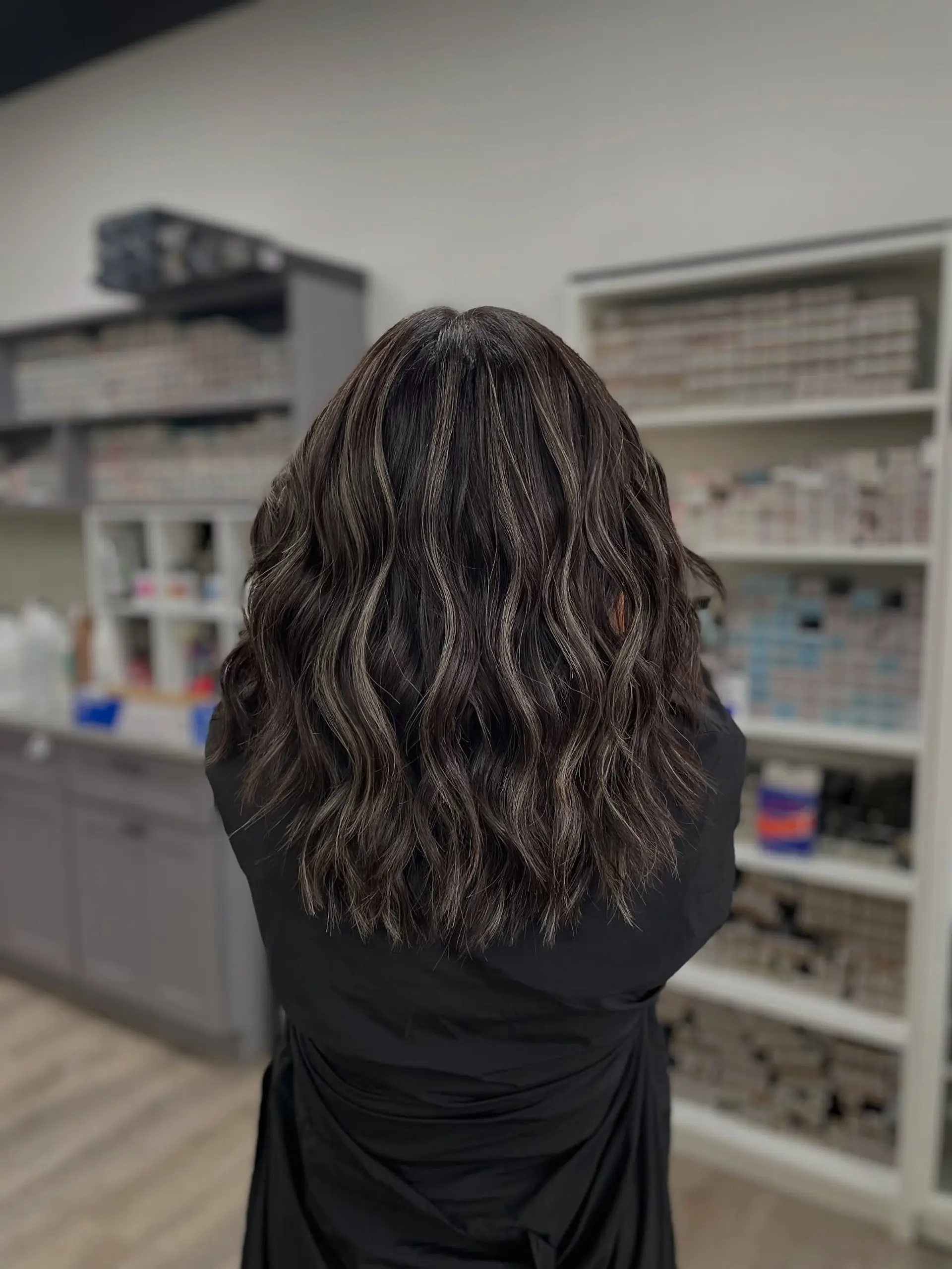 Medium length layered hair styled into loose waves with ash blonde highlights. 1