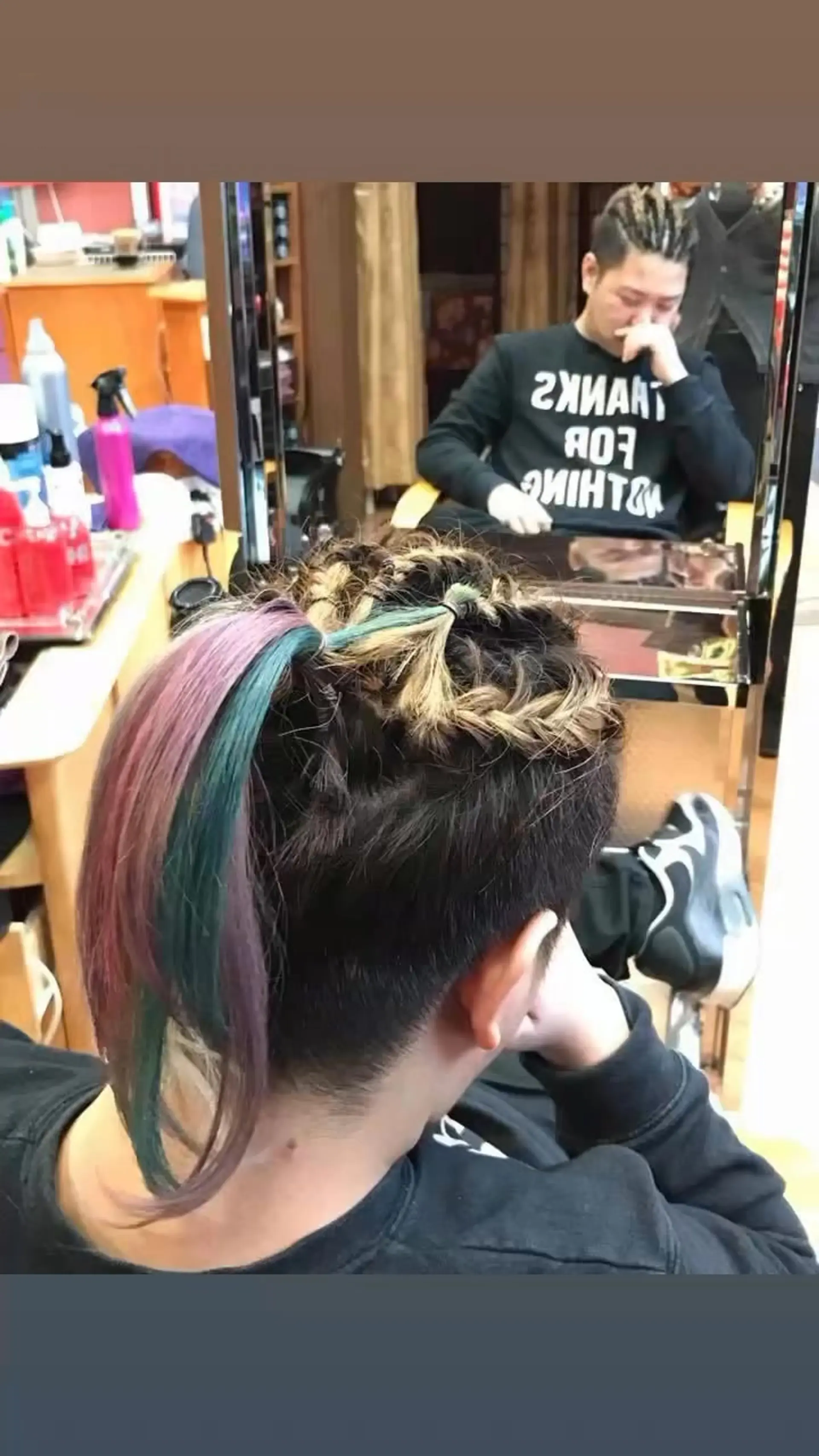 An intricate braided undercut with hair pulled into a ponytail featuring vivid teal, pink, and blonde accents. 1