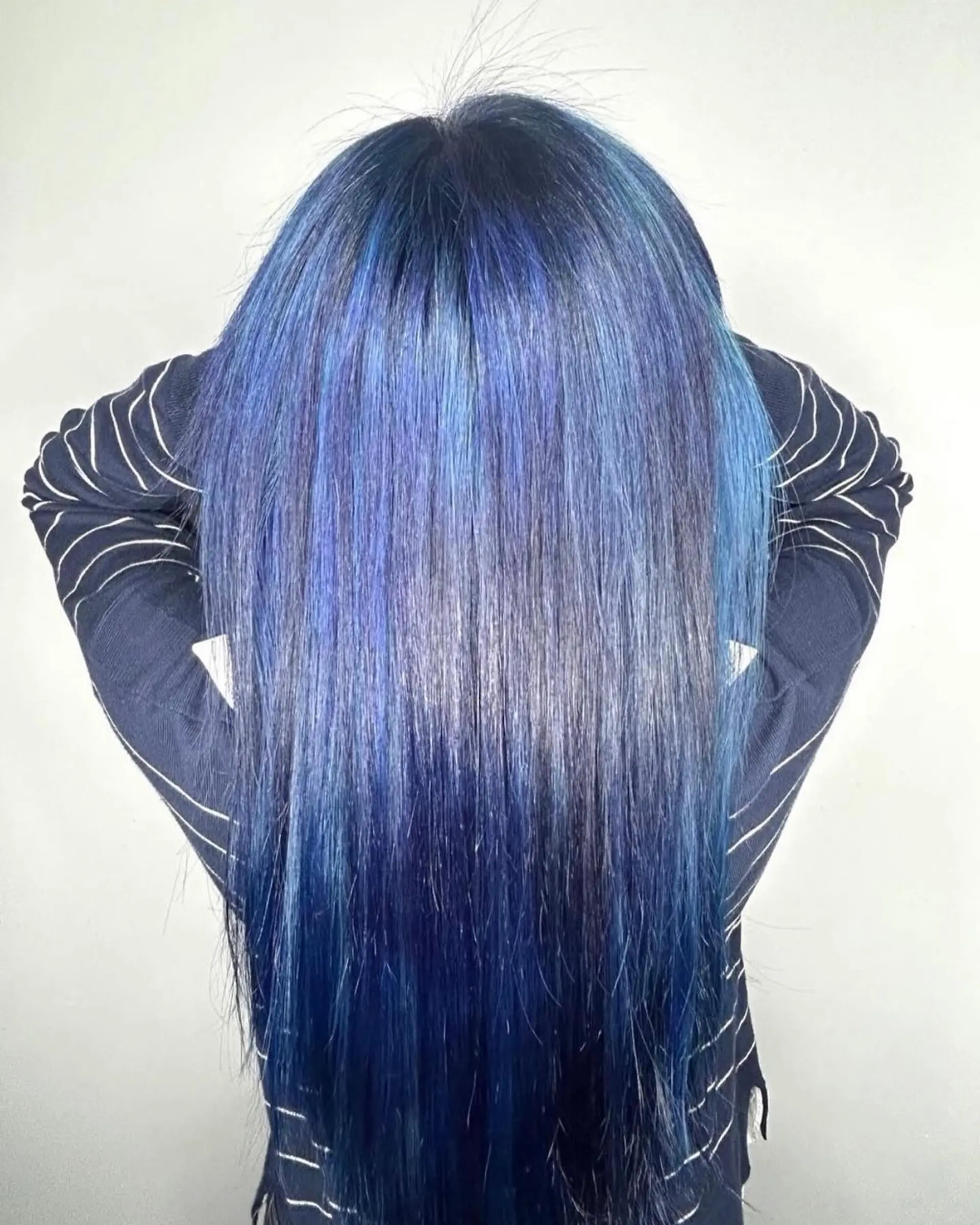 Long, sleek straight hair dyed in multi-dimensional vivid blue tones ranging from navy to bright cobalt. 1