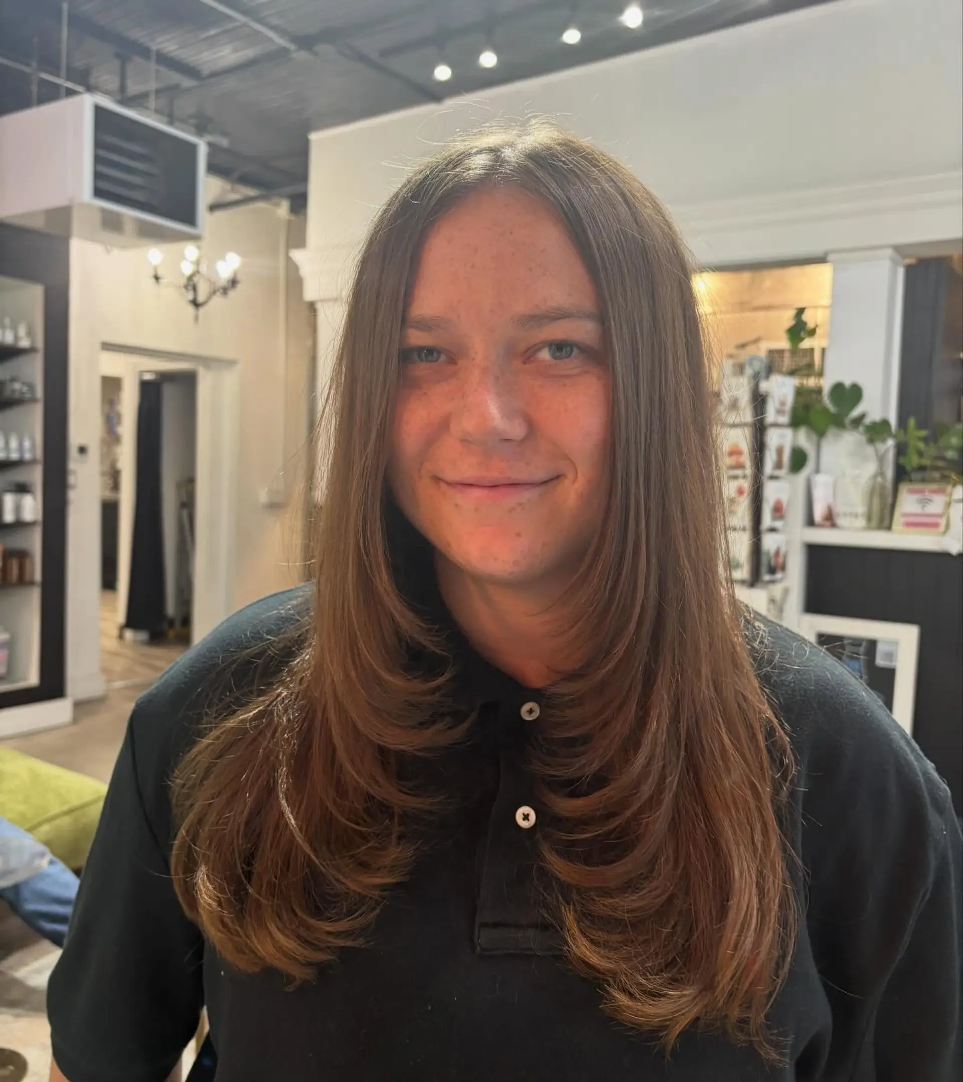 Long brown hair cut with soft, graduated face-framing layers styled smoothly inward. 1