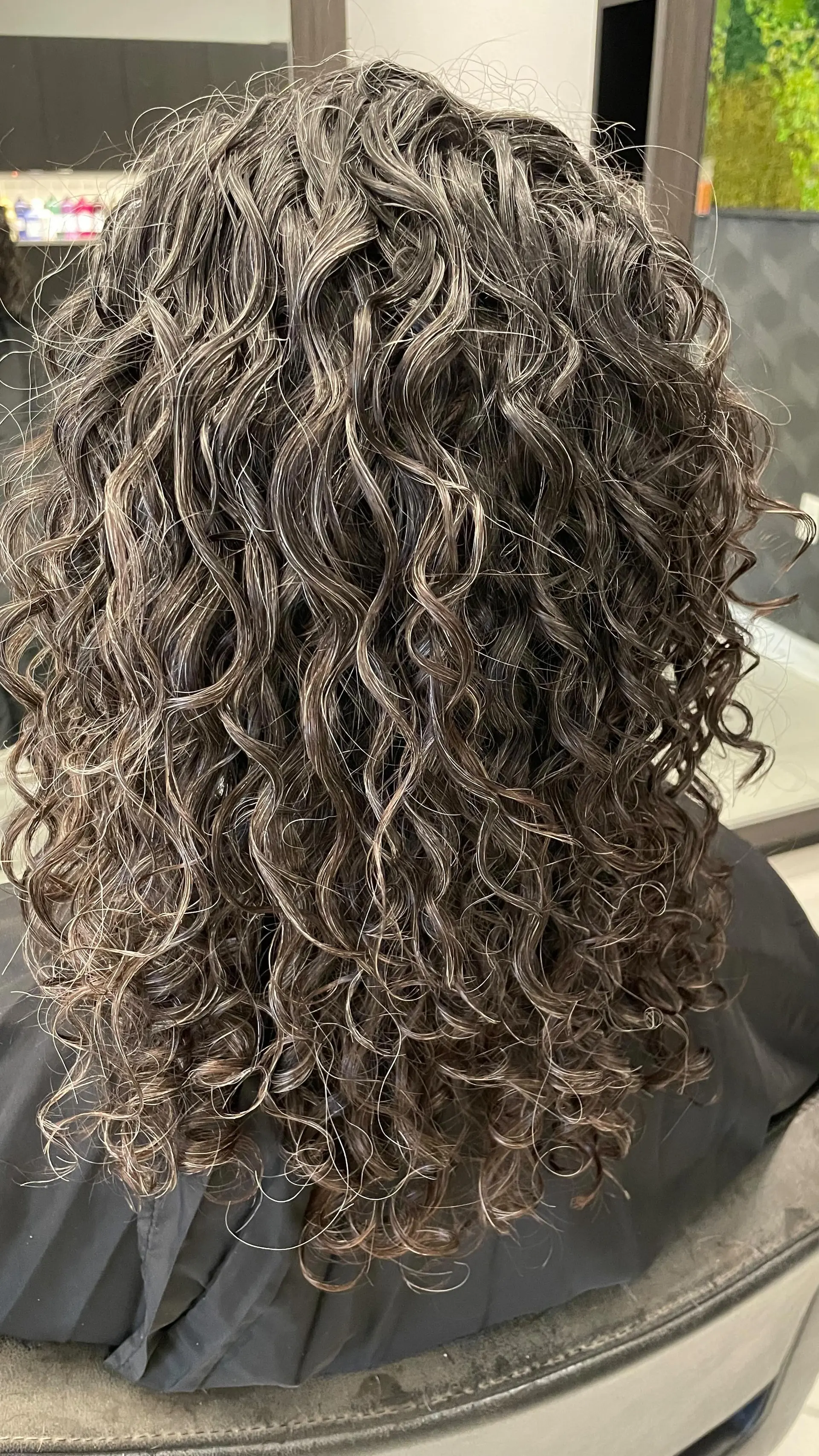 Medium-length, highly defined natural curls with rich dark brown and silver salt-and-pepper dimensional highlights. 1