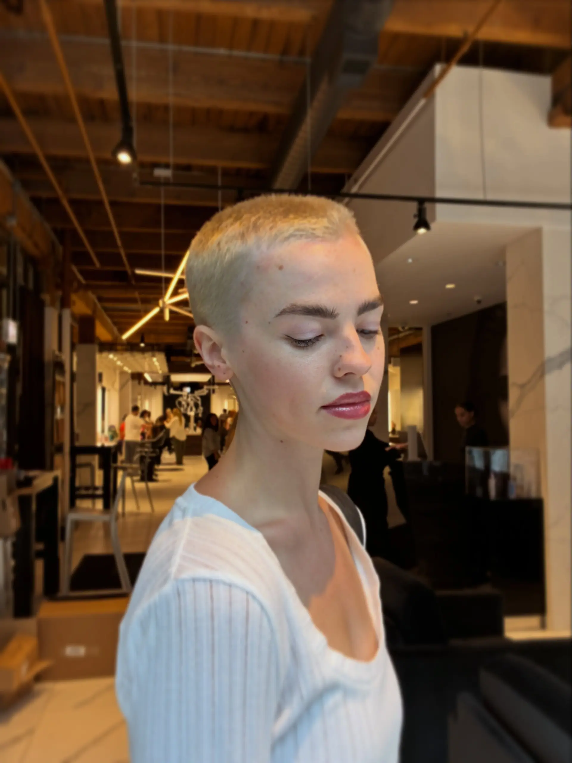 An ultra-short platinum blonde buzz cut cropped closely to the head. 1