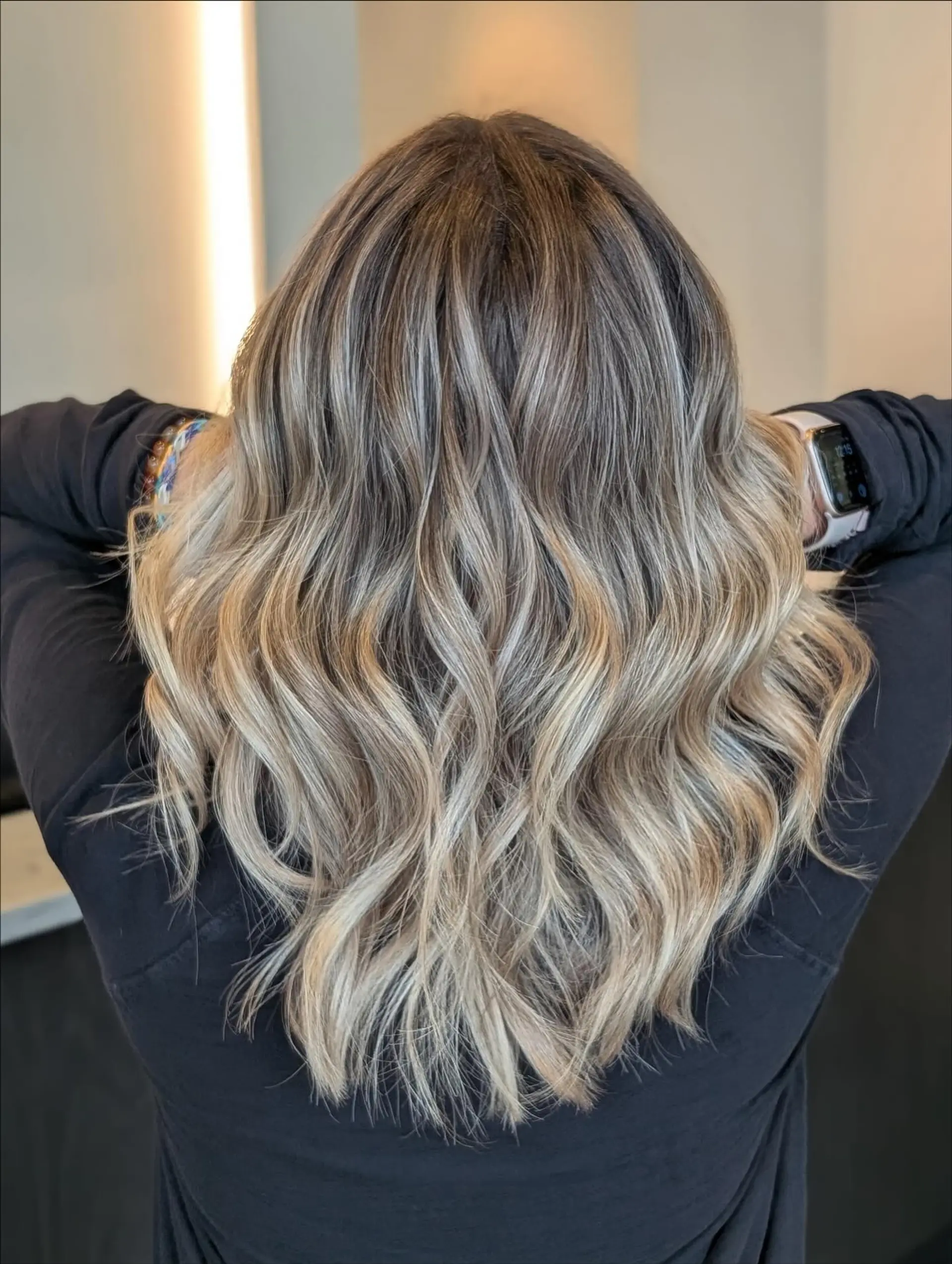 Medium-length dimensional ash blonde foilyage styled in loose, textured waves. 1