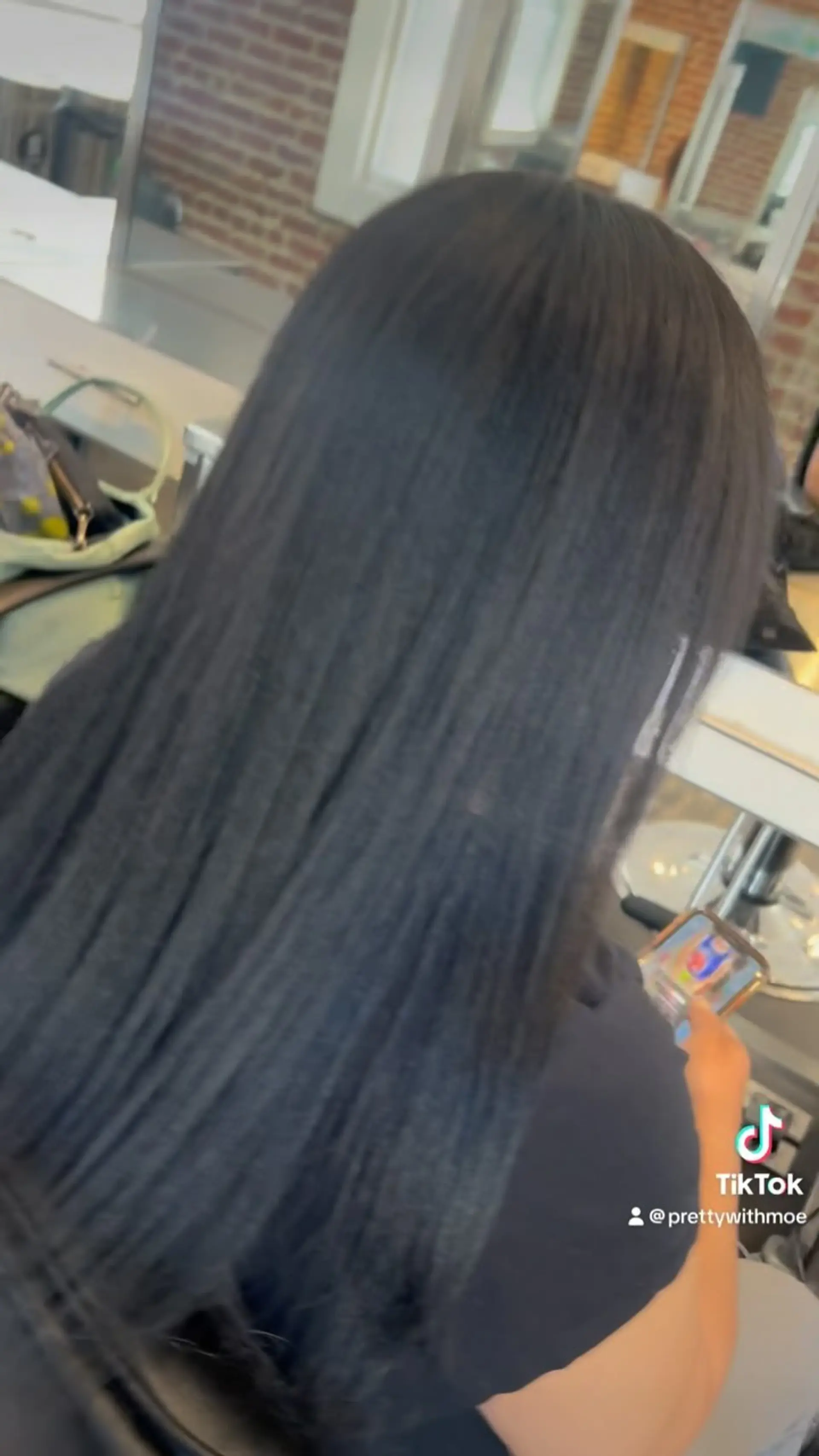Long, glossy black hair styled straight and sleek, falling down the client's back. 1