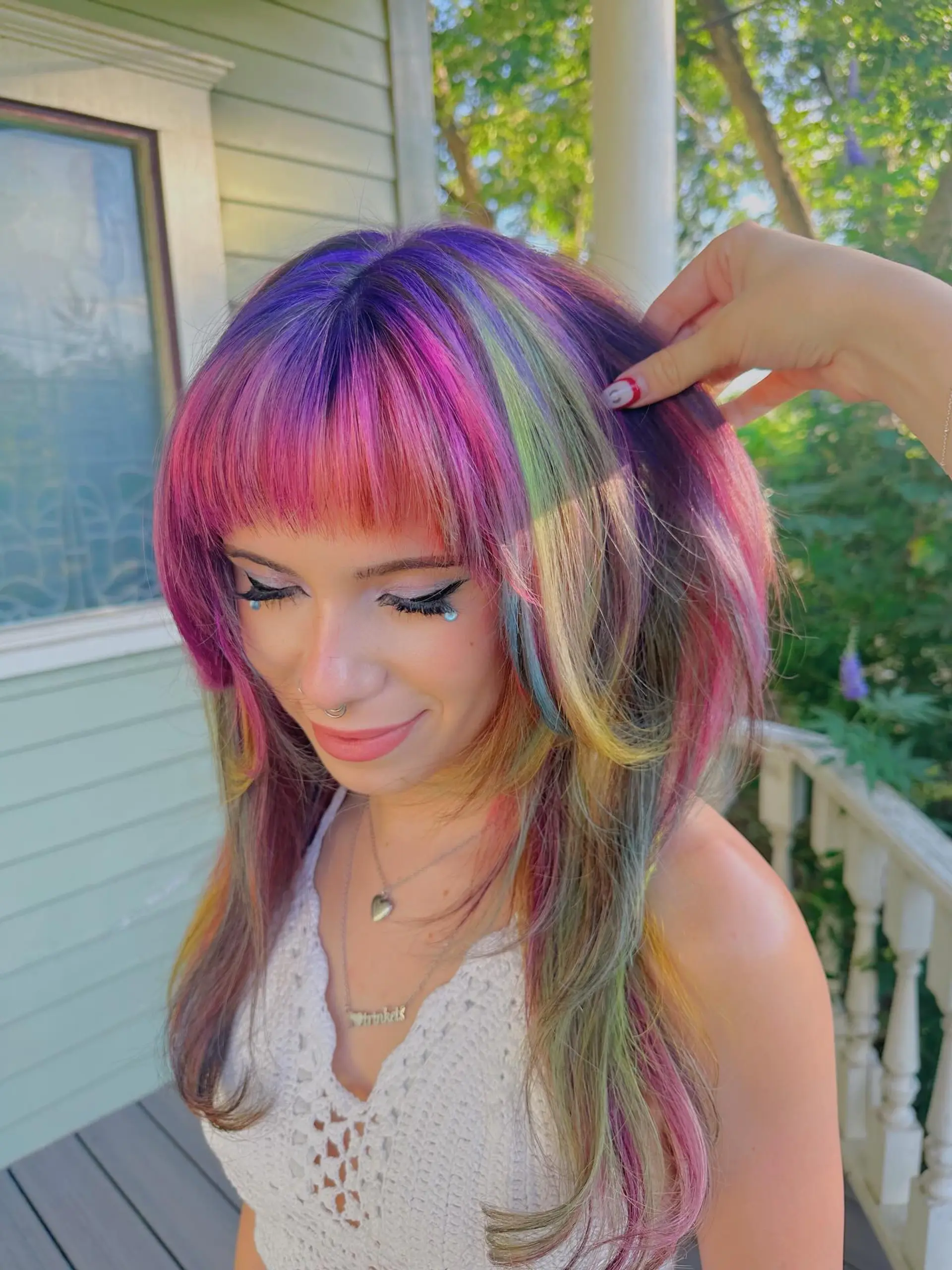 A vibrant and playful medium-length straight hairstyle featuring a full rainbow vivid color transformation. It's cut with face-framing layers and includes a bold, multi-tonal fringe for a distinct, edgy aesthetic. 2