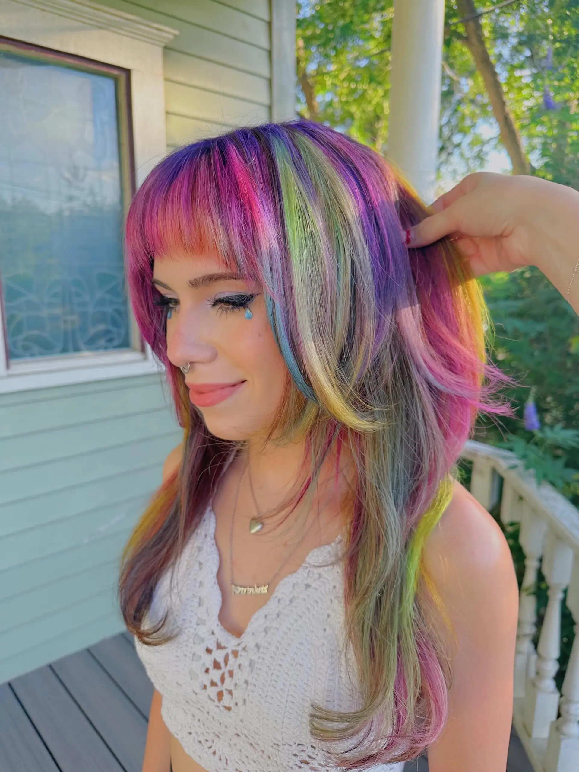 A vibrant and playful medium-length straight hairstyle featuring a full rainbow vivid color transformation. It's cut with face-framing layers and includes a bold, multi-tonal fringe for a distinct, edgy aesthetic. 3