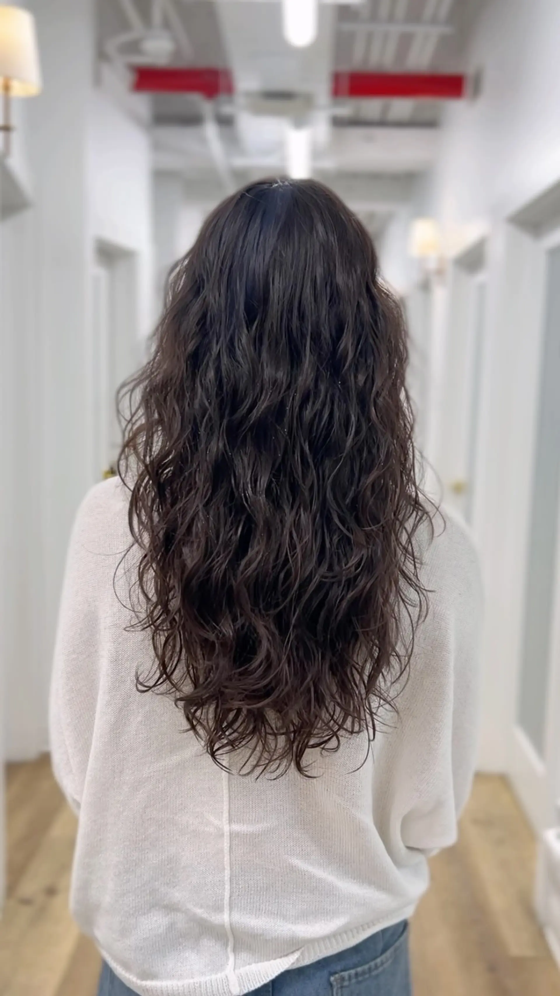 Long, layered dark brown hair featuring defined digital perm waves that provide natural texture and movement. 1