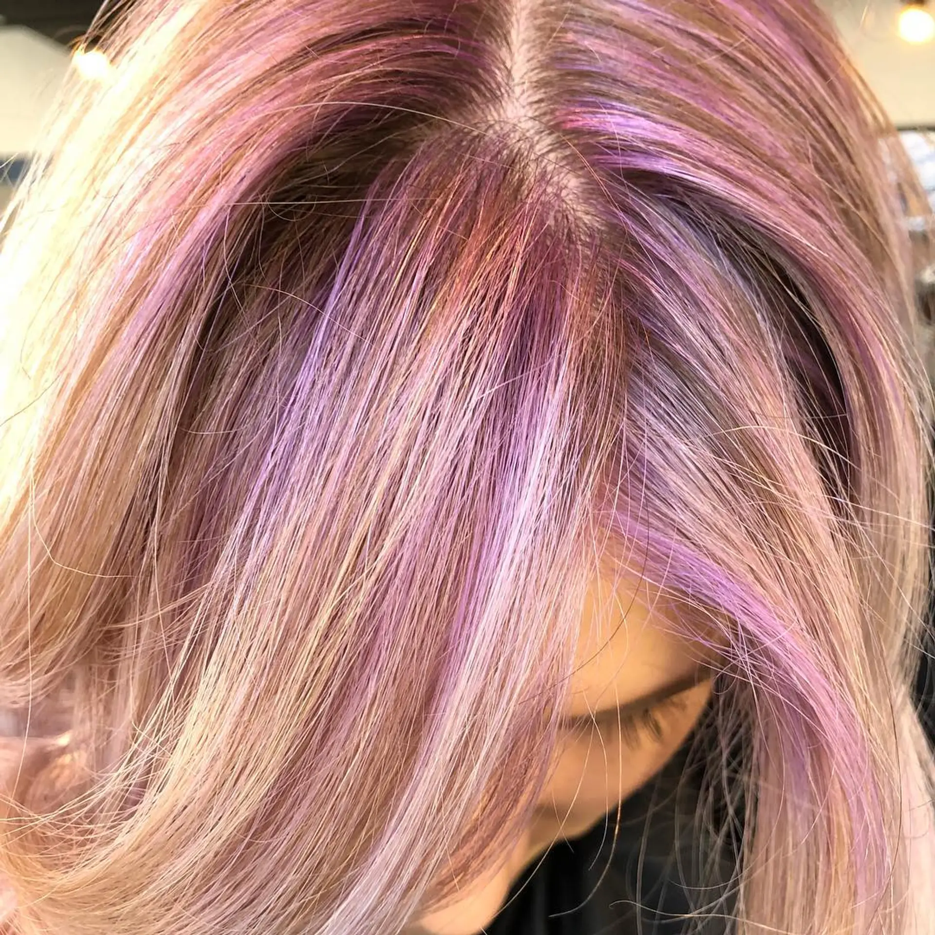 A subtle violet root melt blended seamlessly into soft blonde hair. 1
