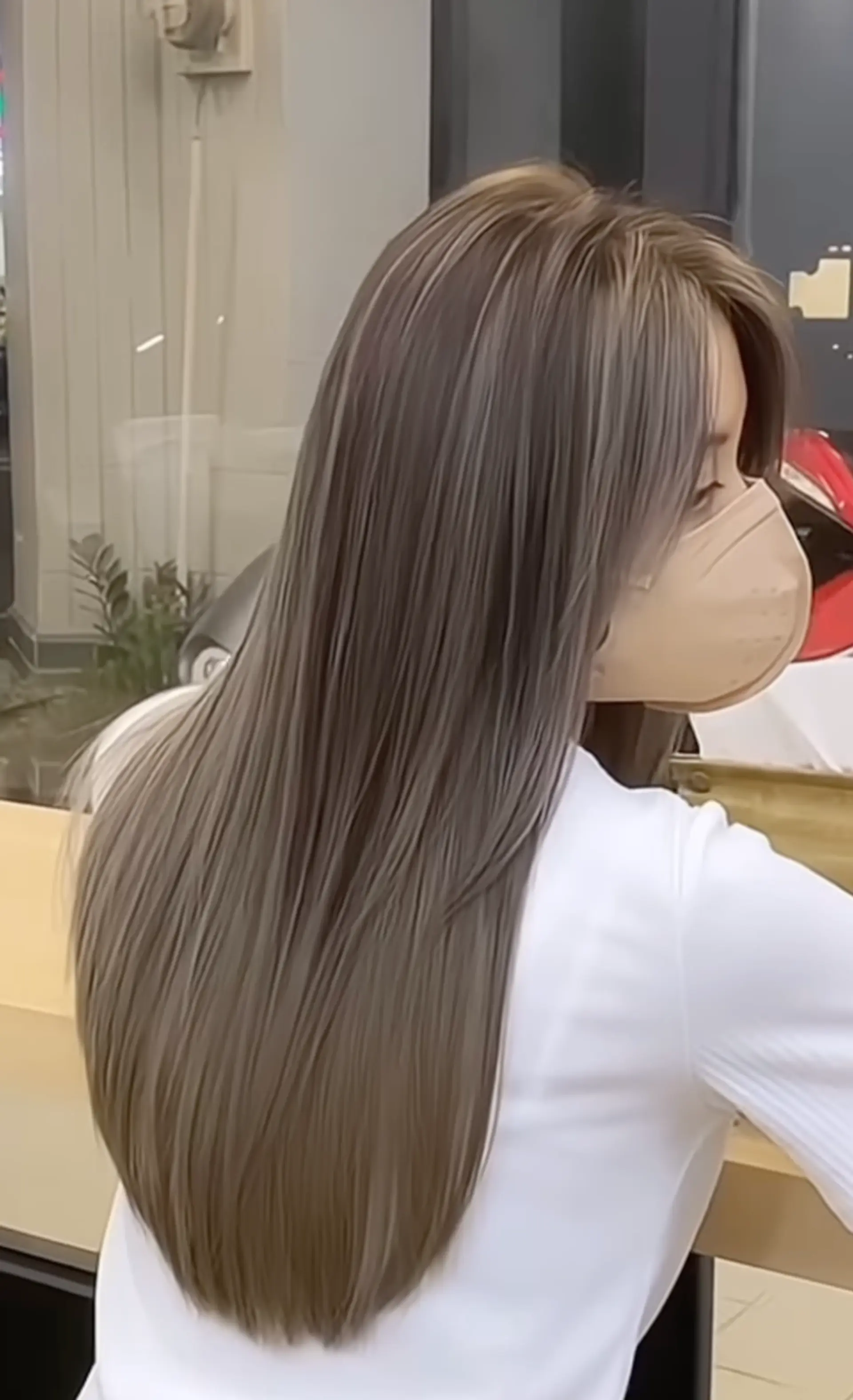 Long, straight hair with a sleek and polished ash brown color featuring silver undertones, creating a soft gradient effect. The style is characterized by its smooth finish and natural shine. 1