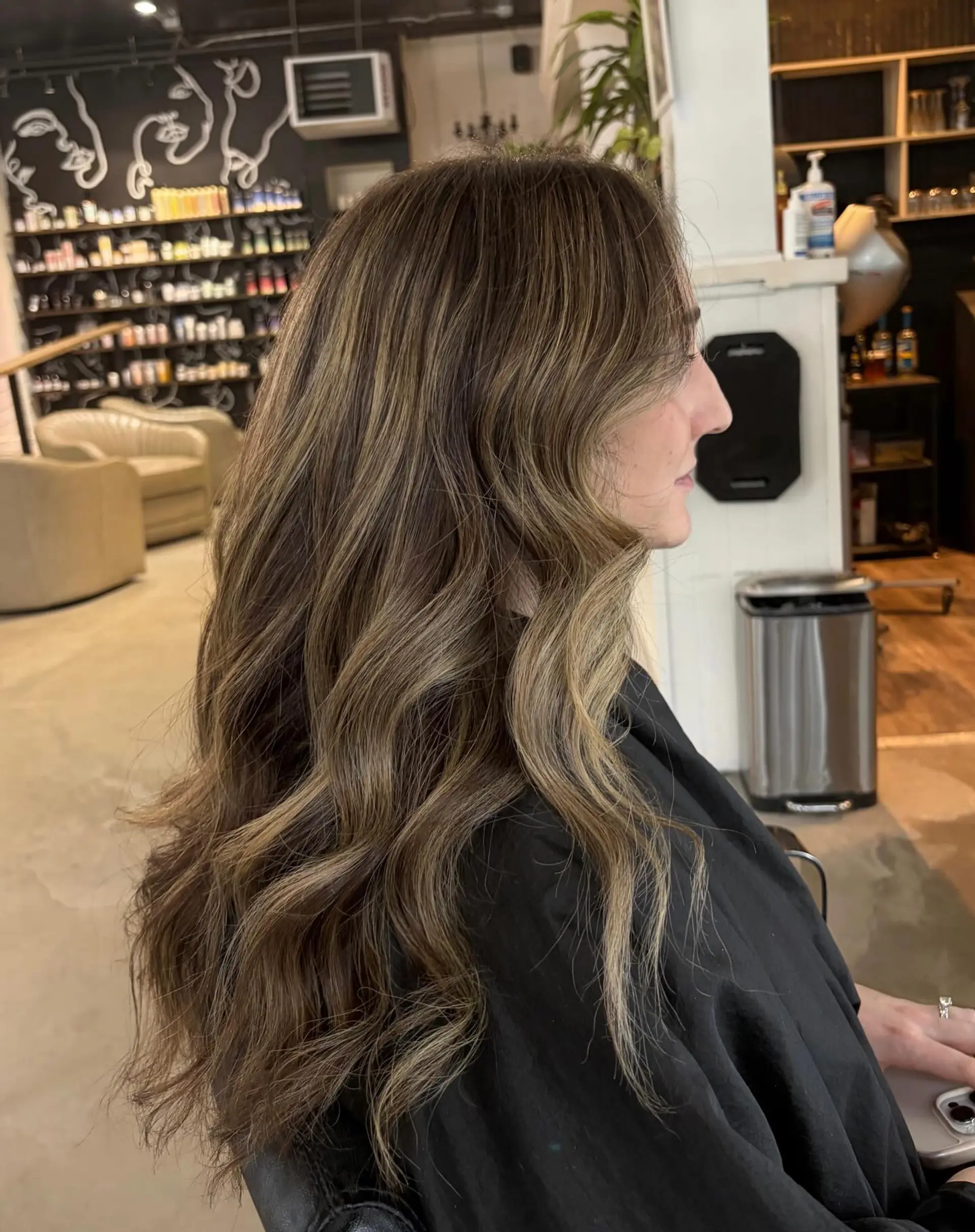 Long dimensional bronde hair styled with seamless highlights and soft, loose waves. 1