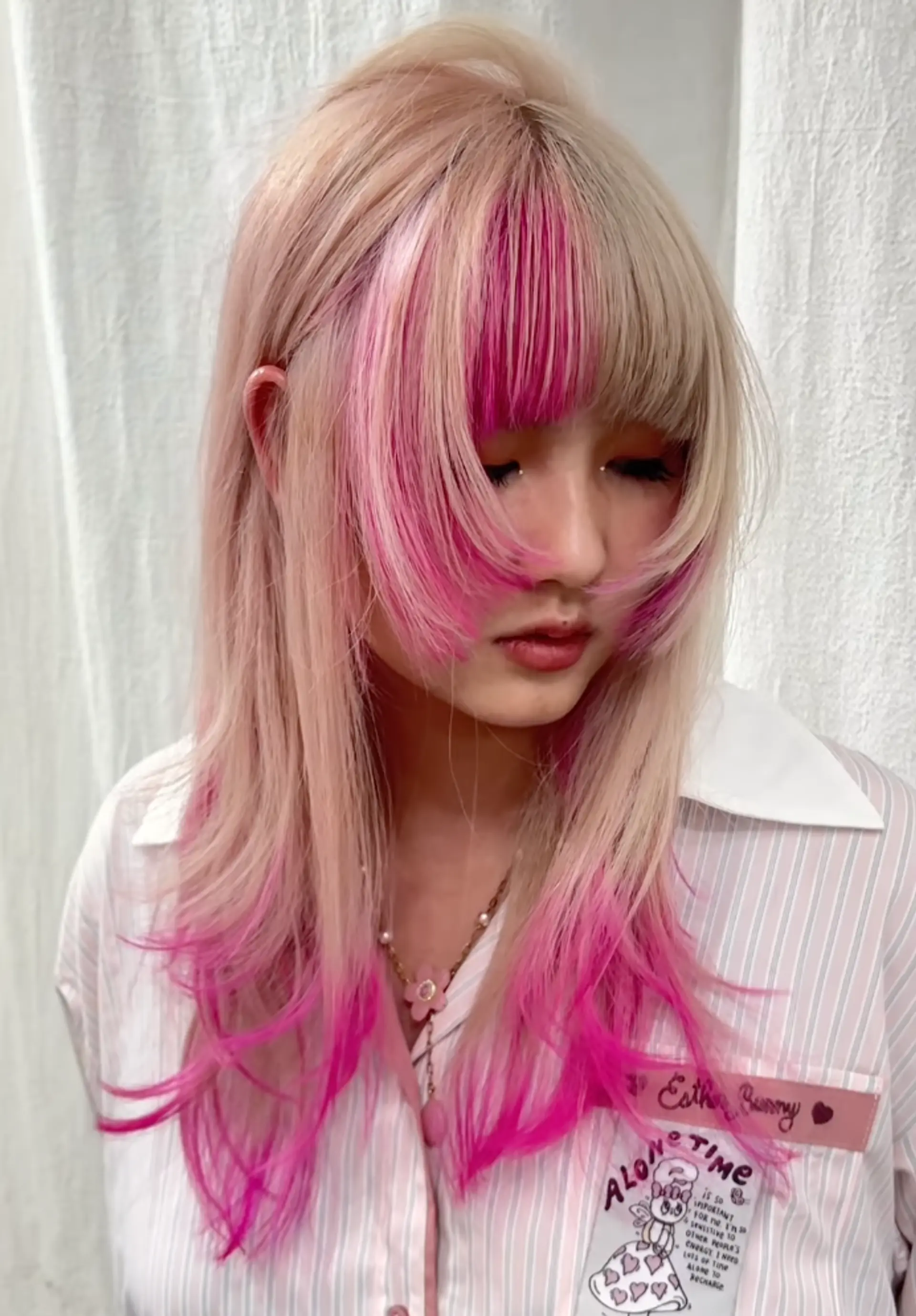 Long, straight blonde hair with vibrant pink ombre tips, layered and face-framing bangs for softness and volume. 1