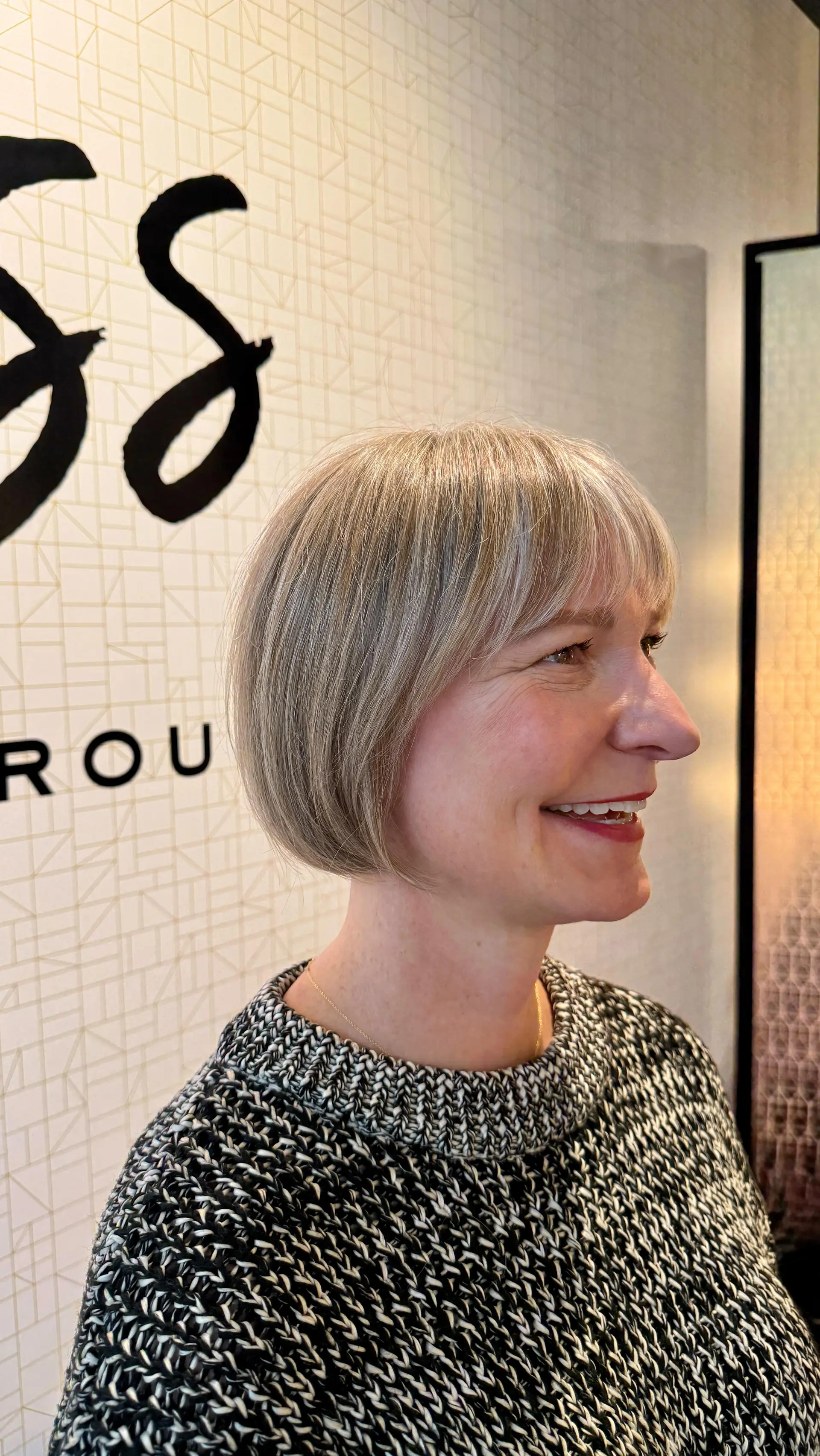 A sleek, chin-length classic bob with soft straight fringe and multidimensional cool blonde highlights. 1