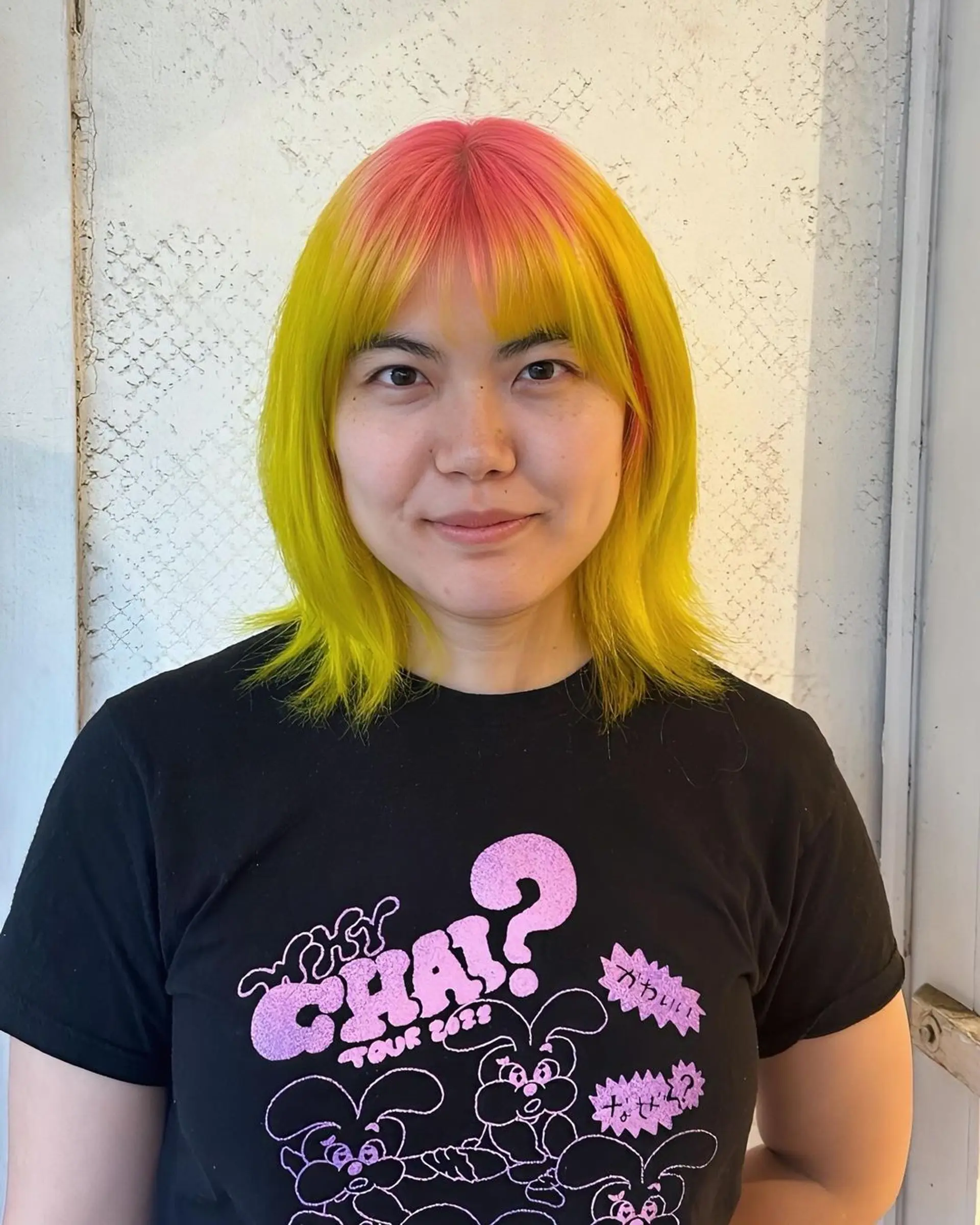 Medium-length straight hair with a playful blend of neon yellow, pink, and orange hues, characterized by blunt layers and a straight fringe. 1