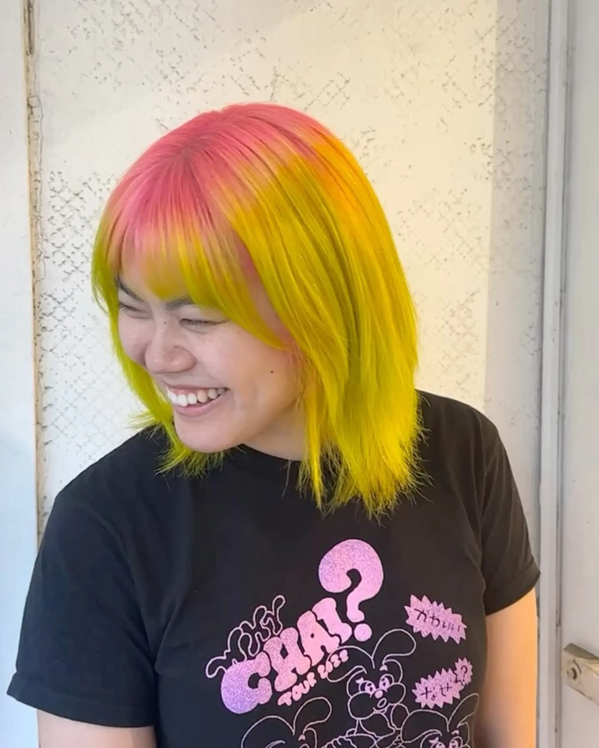 Medium-length straight hair with a playful blend of neon yellow, pink, and orange hues, characterized by blunt layers and a straight fringe. 2