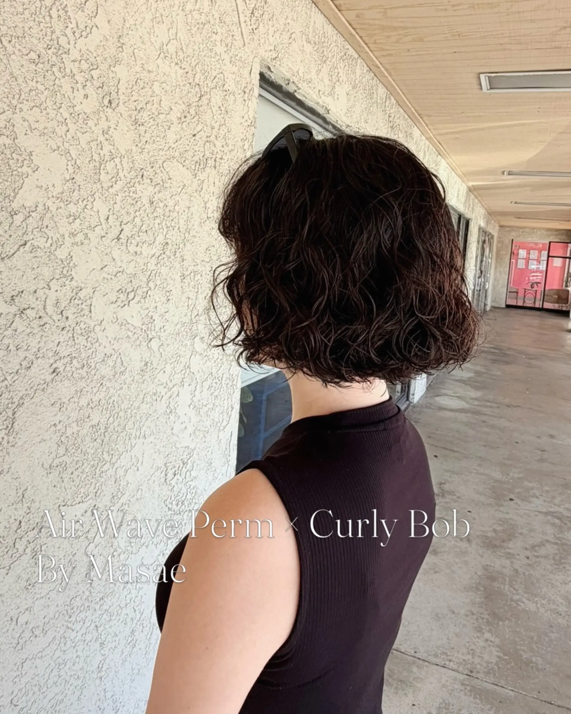 A textured chin-length bob styled with soft, airy curls and natural wave definition. 1