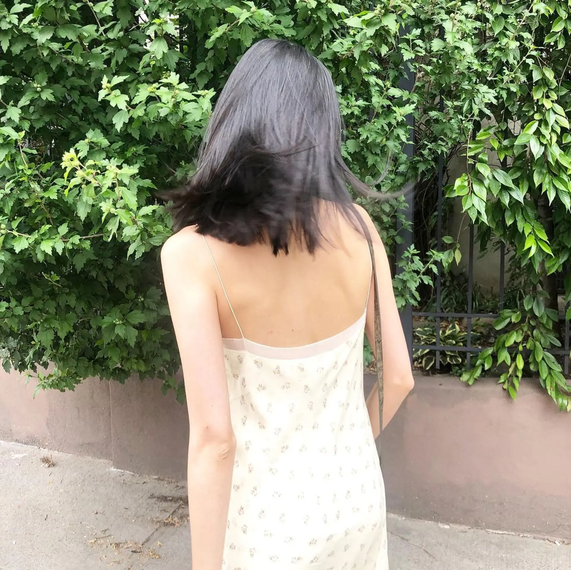 This hairstyle features medium-length straight black hair with choppy ends, layered sections, and curtain bangs framing the face by Takeo. 2