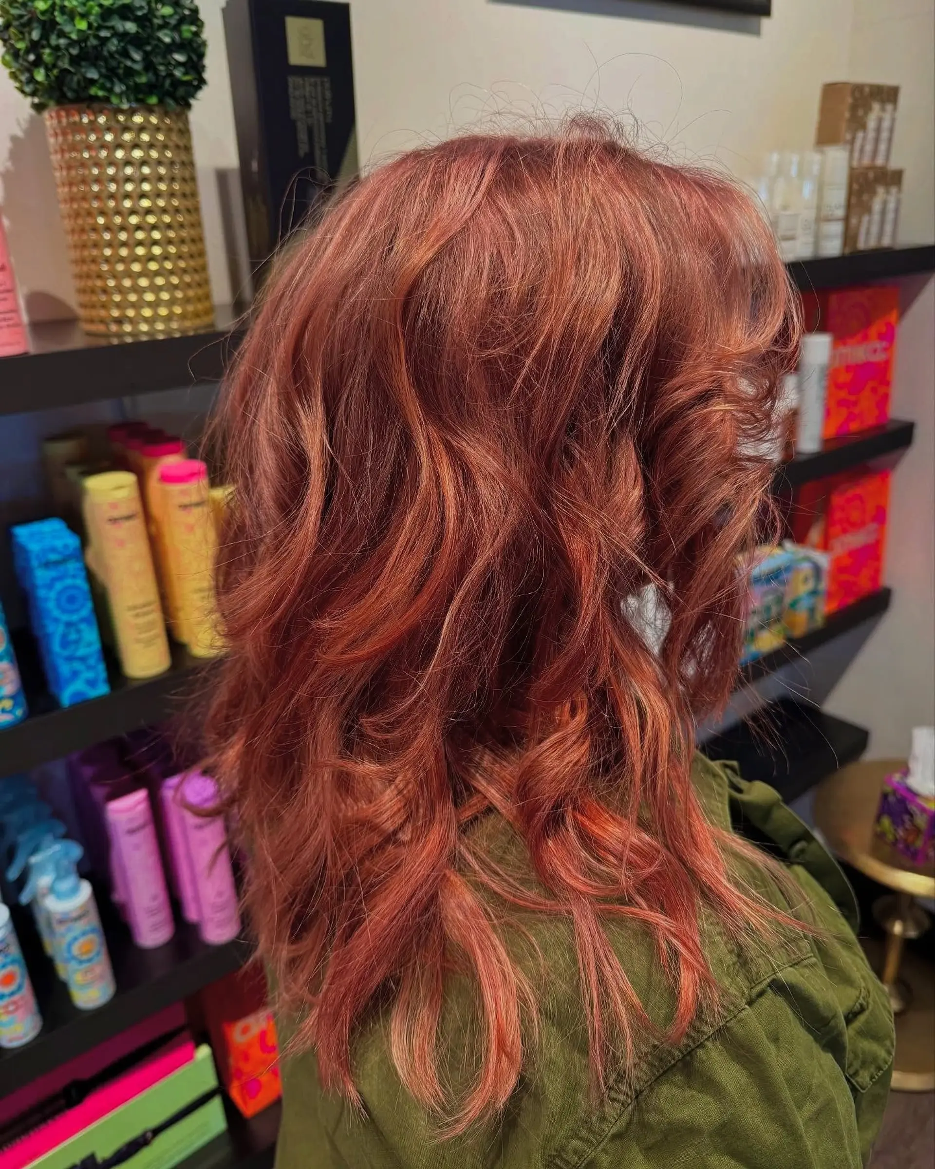 Long layered hair colored in a vibrant copper-red tone, styled with loose, dimensional waves. 1