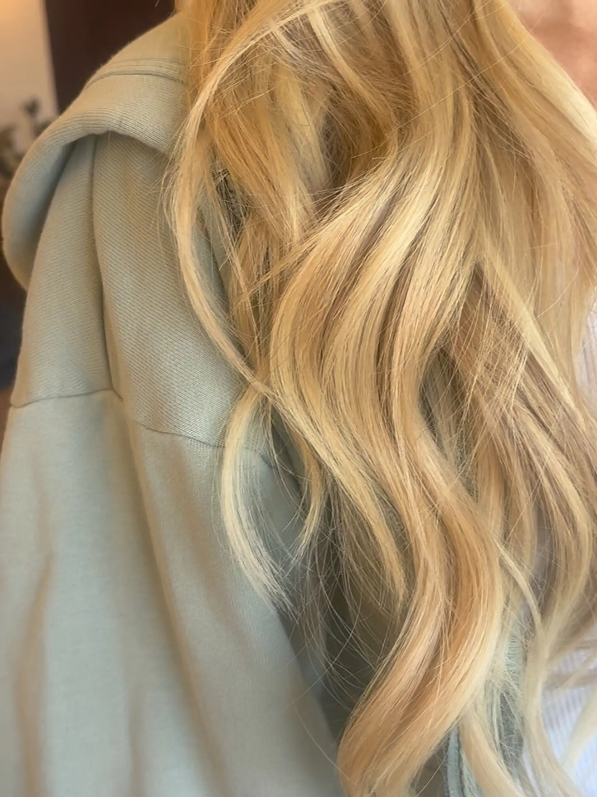 Long golden blonde hair styled into soft, loose dimensional waves. 1