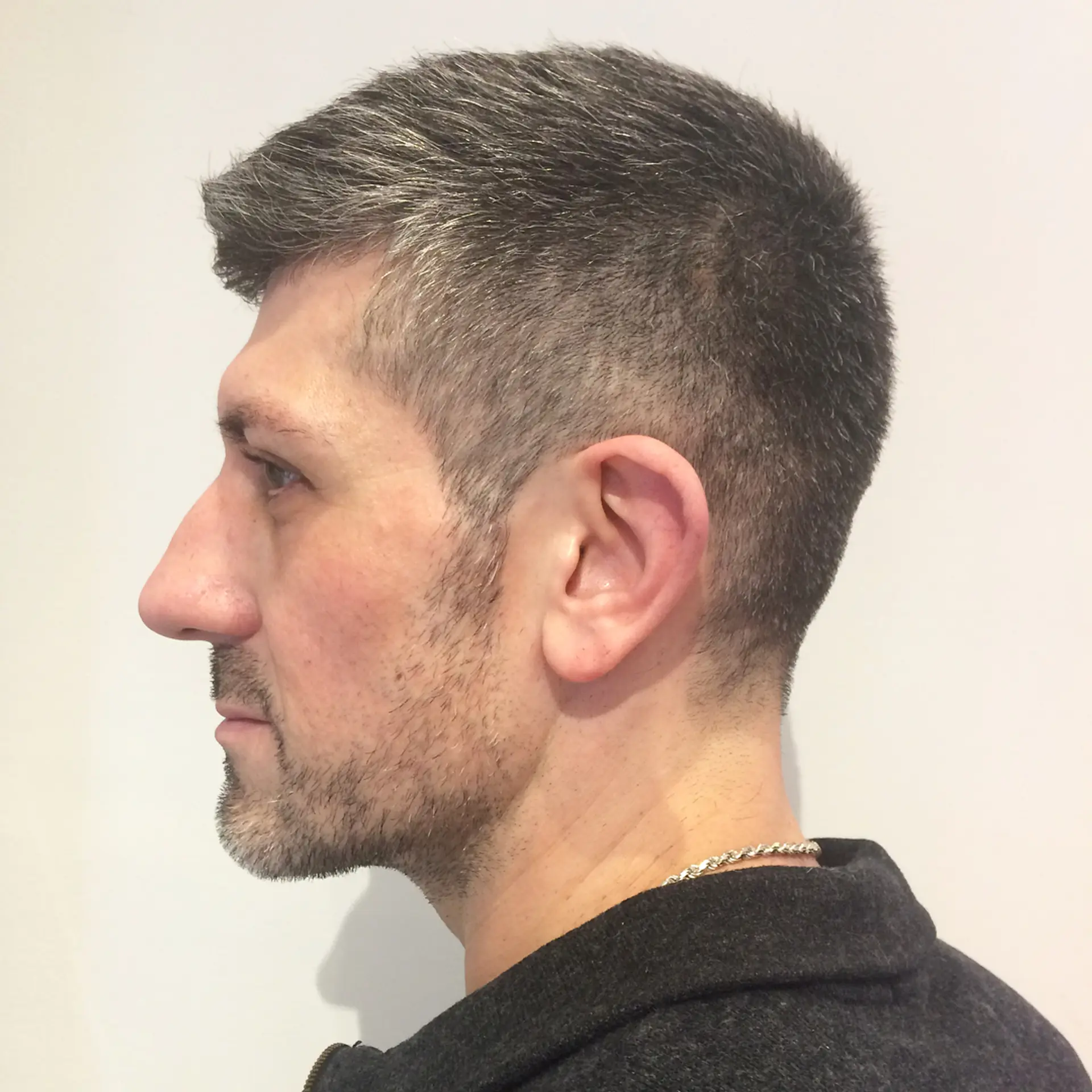 A classic taper fade haircut with short, textured hair on top. 1