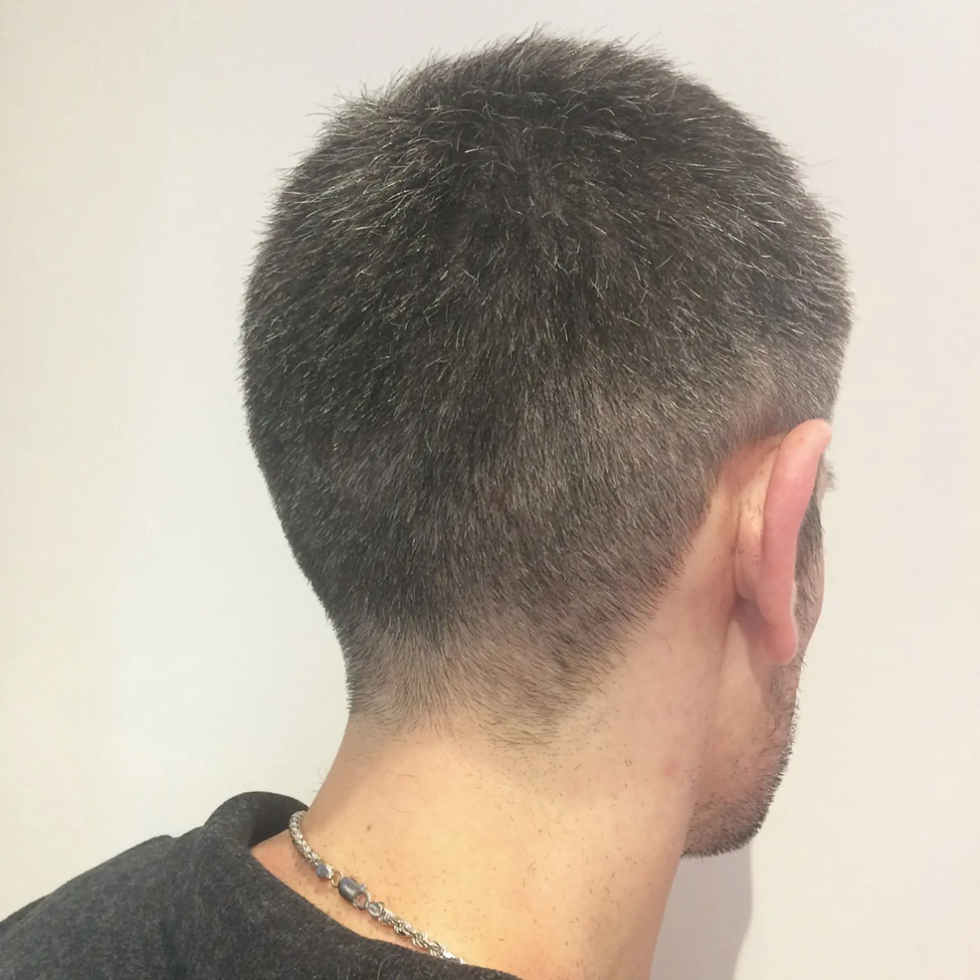 A classic taper fade haircut with short, textured hair on top. 2