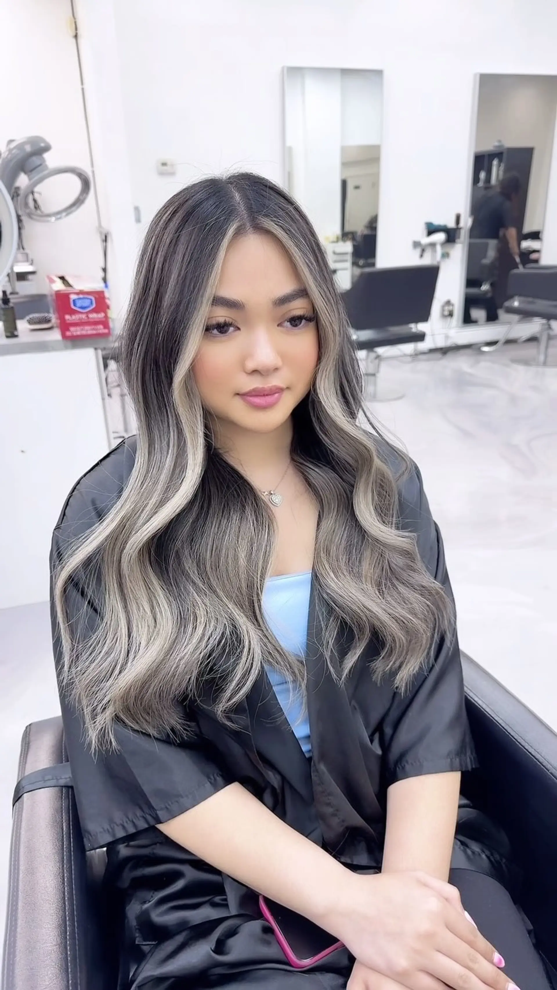 Long cool-toned ash blonde balayage featuring bright face-framing highlights and loose, polished waves. 1