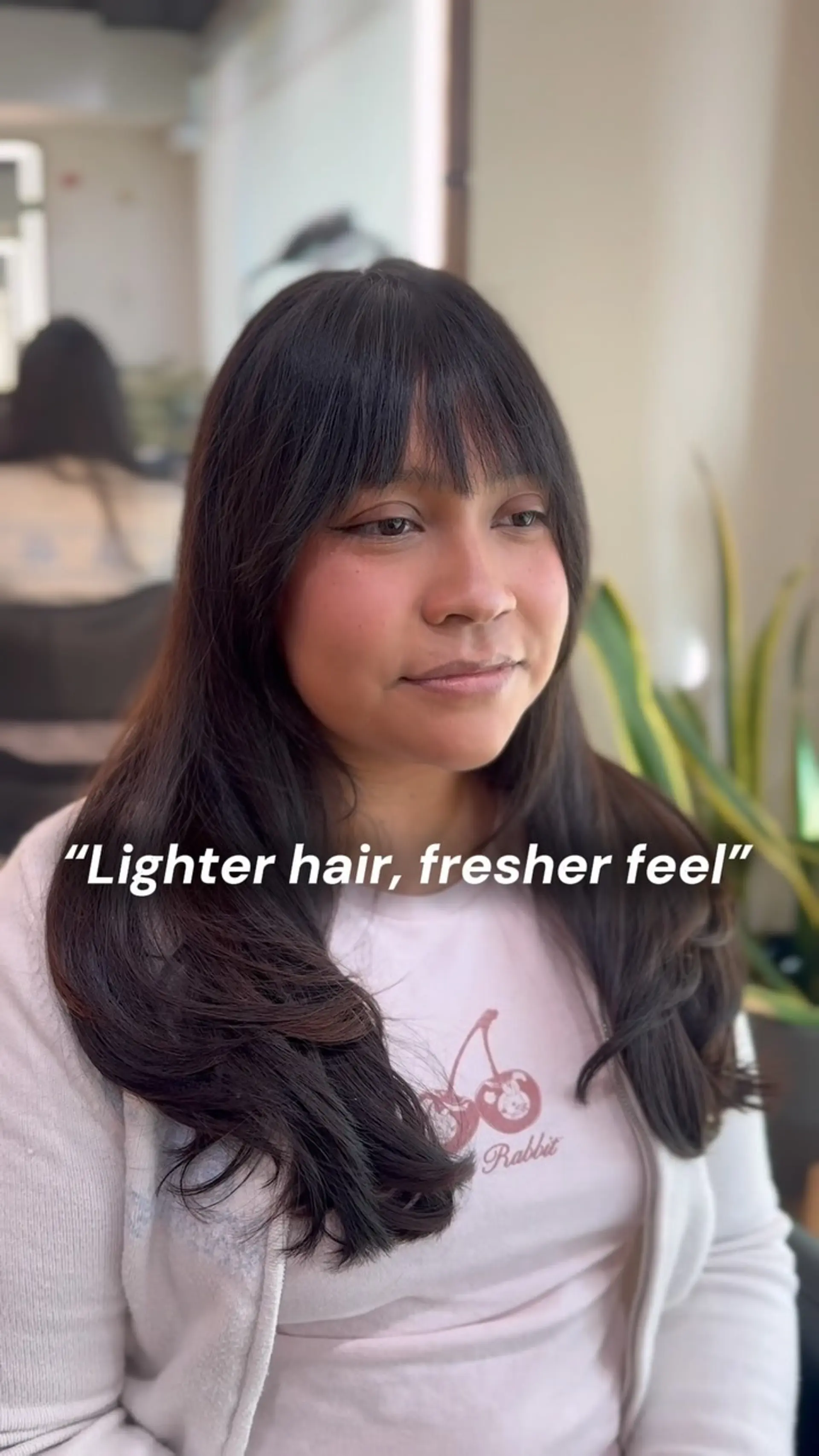 Long dark brown hair cut with soft low layers and wispy, eye-skimming bangs. 1