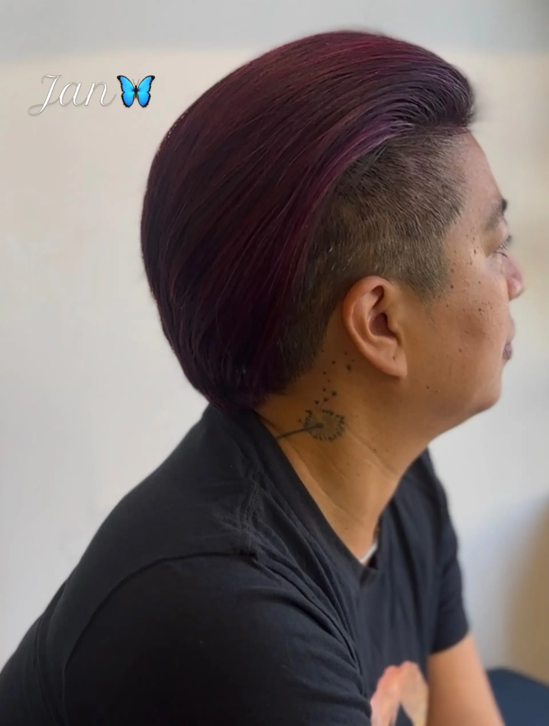 Short undercut hairstyle featuring closely clipped sides and a longer, slicked-back top tinted in rich magenta and purple tones. 1
