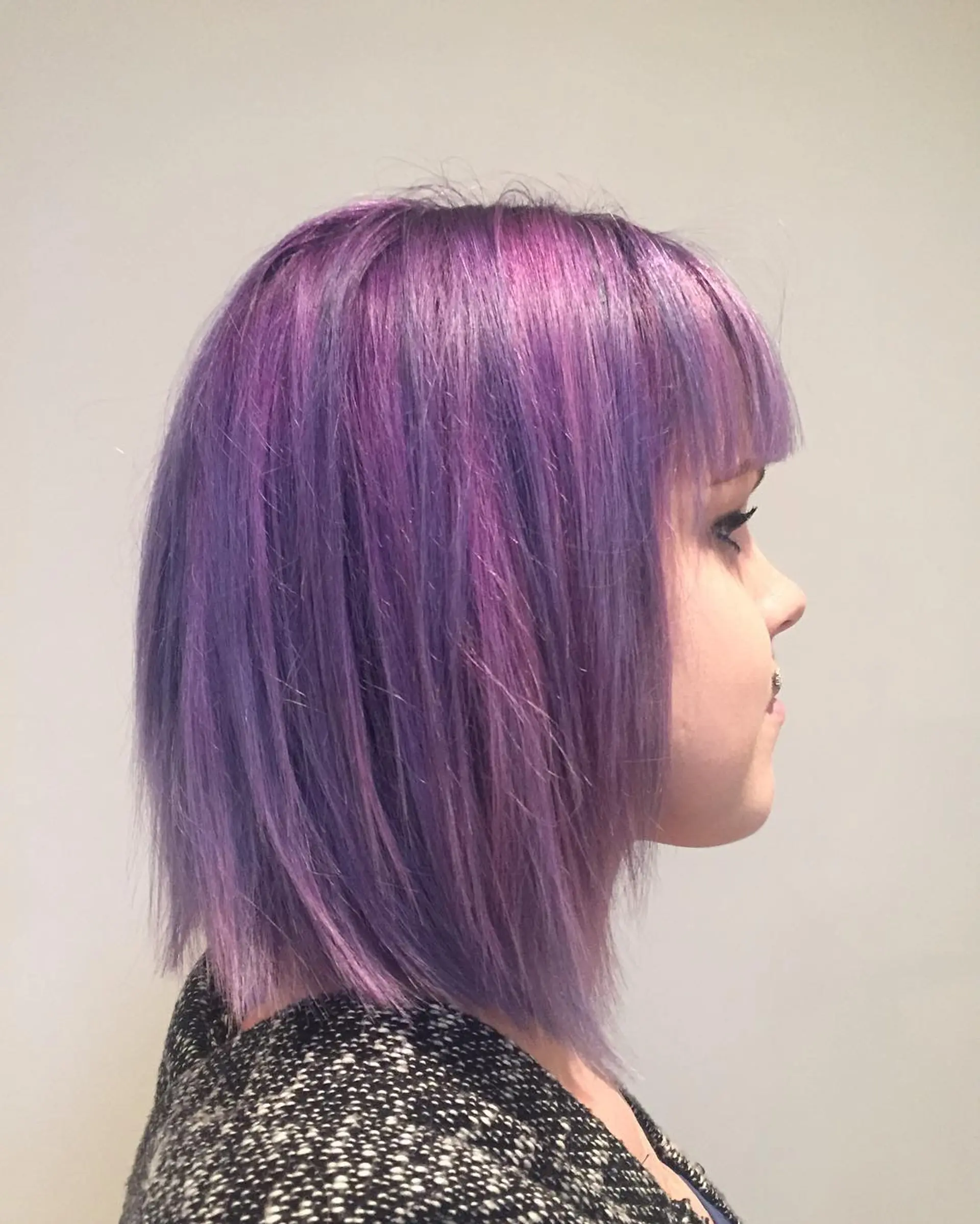 A medium-length blunt bob with straight hair and bangs, featuring a vibrant purple and pink color combination. 1