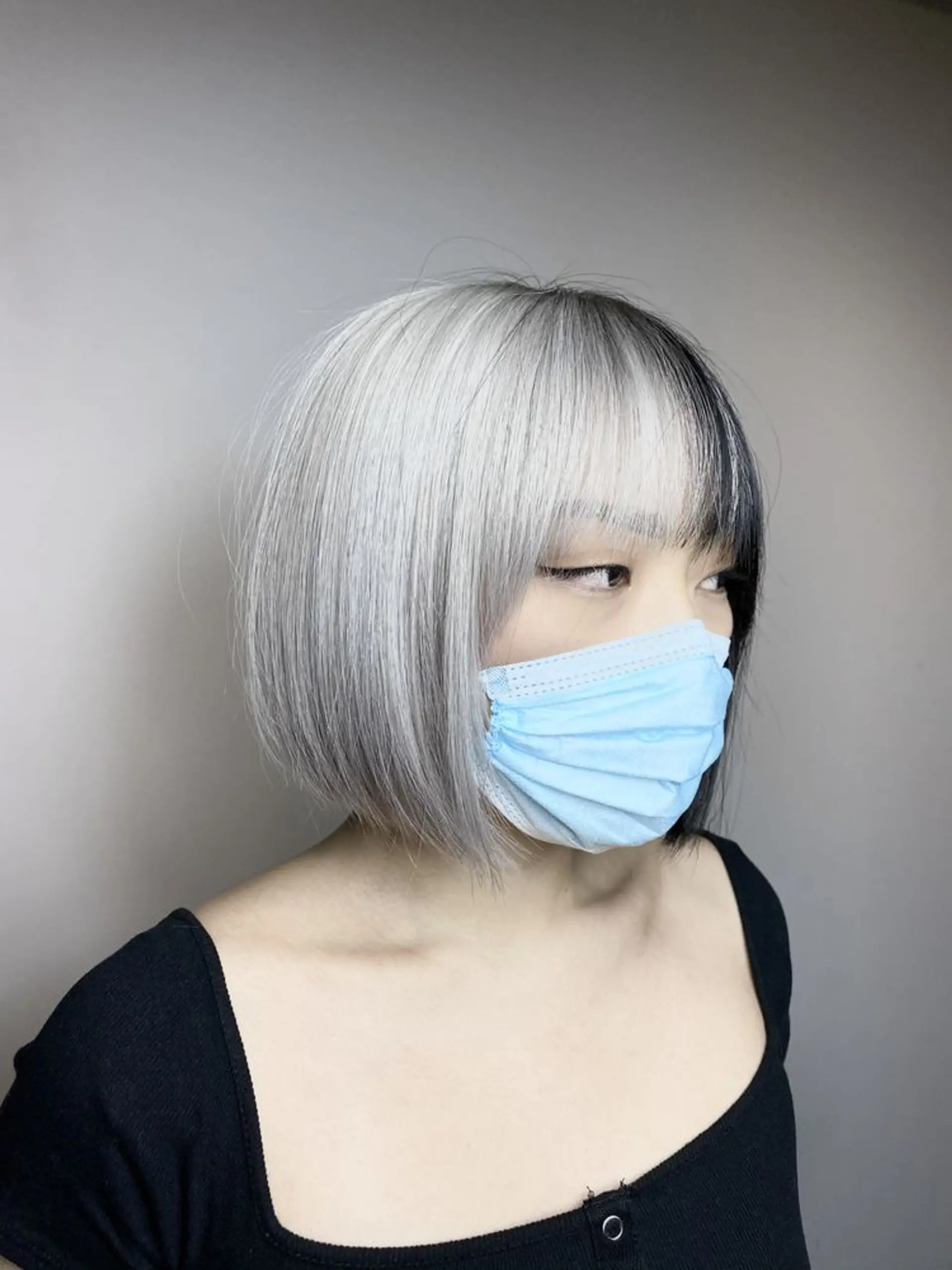 Short bob cut with a two-tone look, featuring platinum blonde and black colors, and blunt bangs. 1