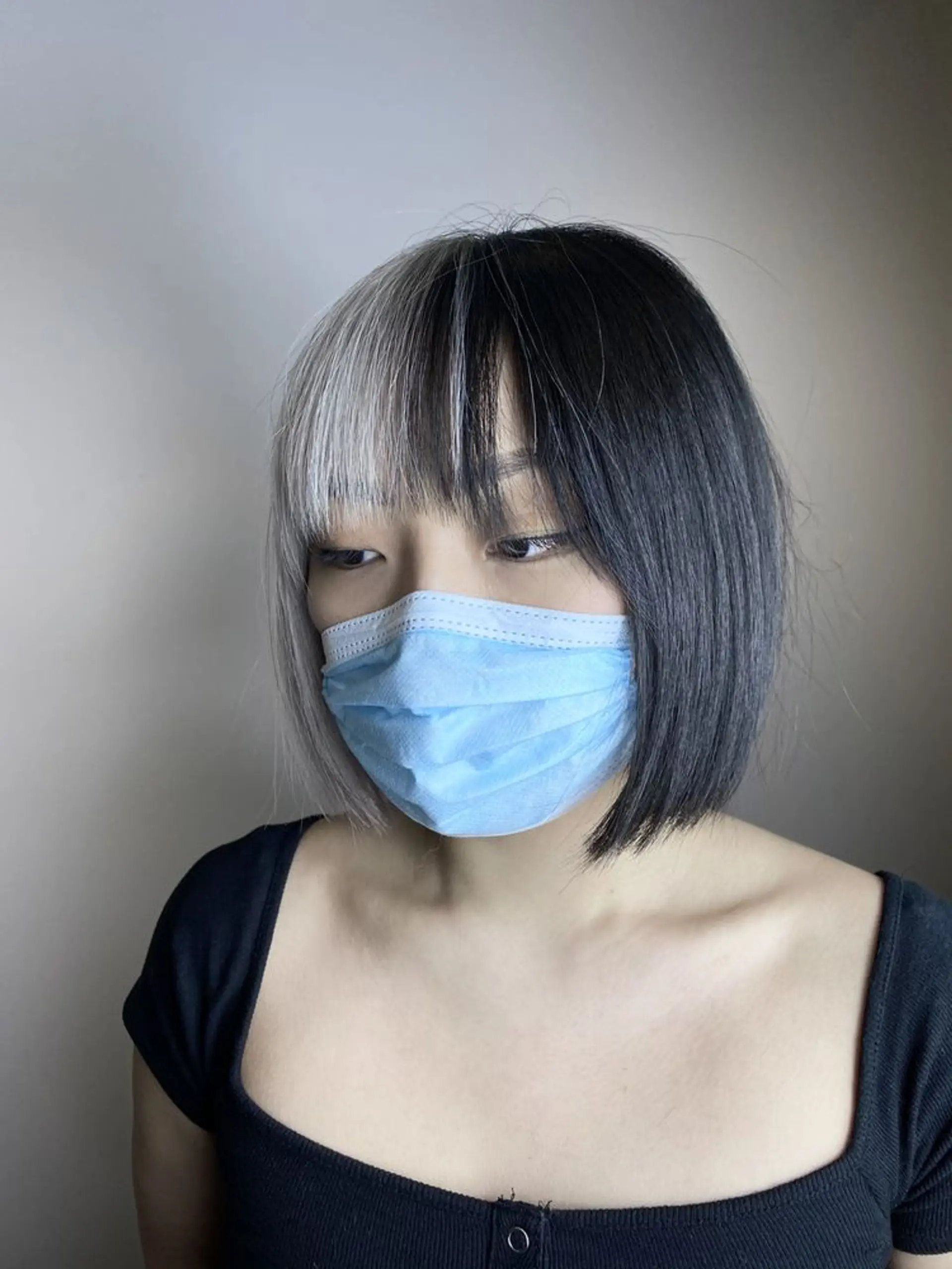 Short bob cut with a two-tone look, featuring platinum blonde and black colors, and blunt bangs. 2