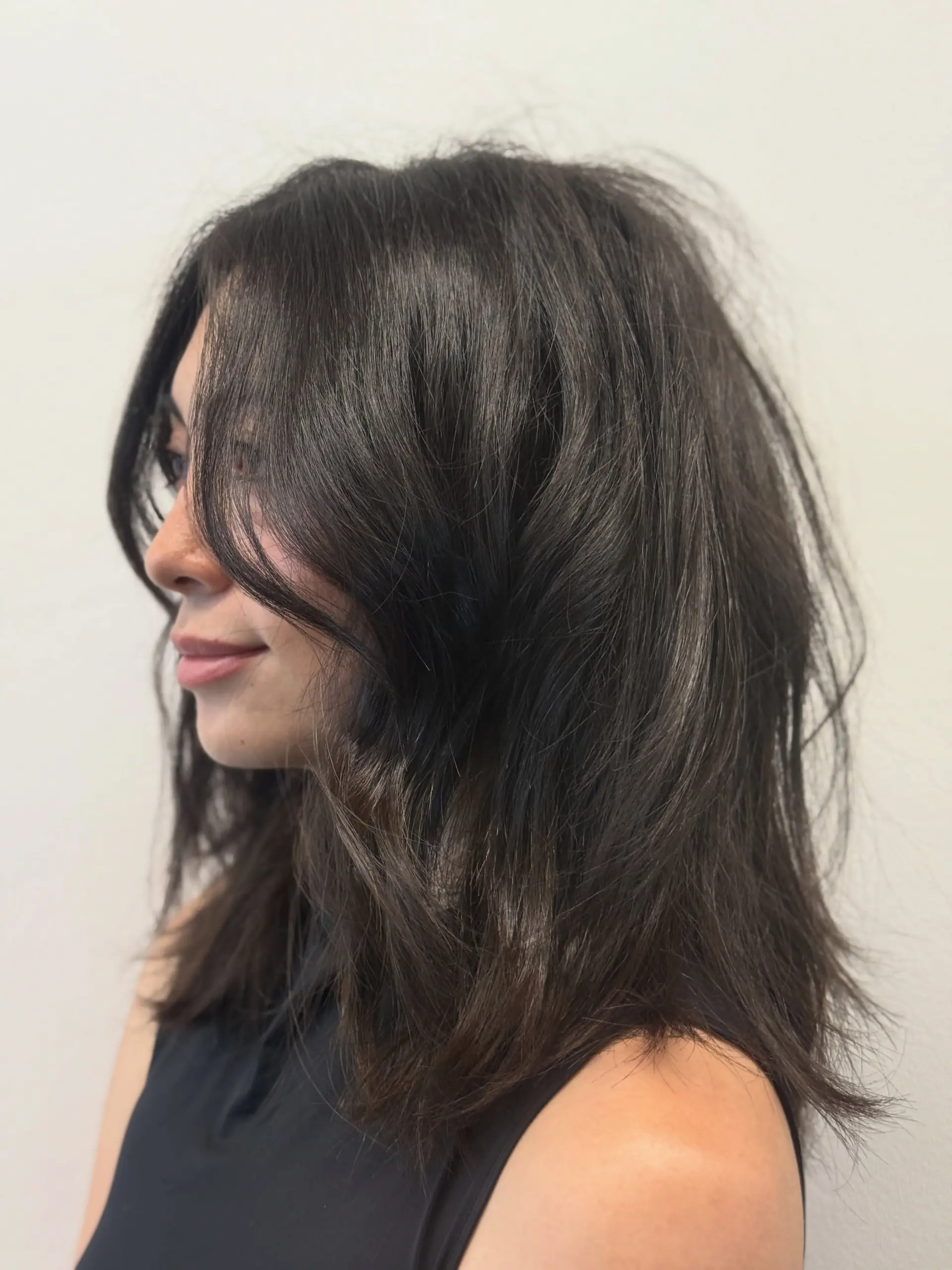 Dark brown medium-length haircut featuring face-framing curtain bangs and soft, piecey layers. 1