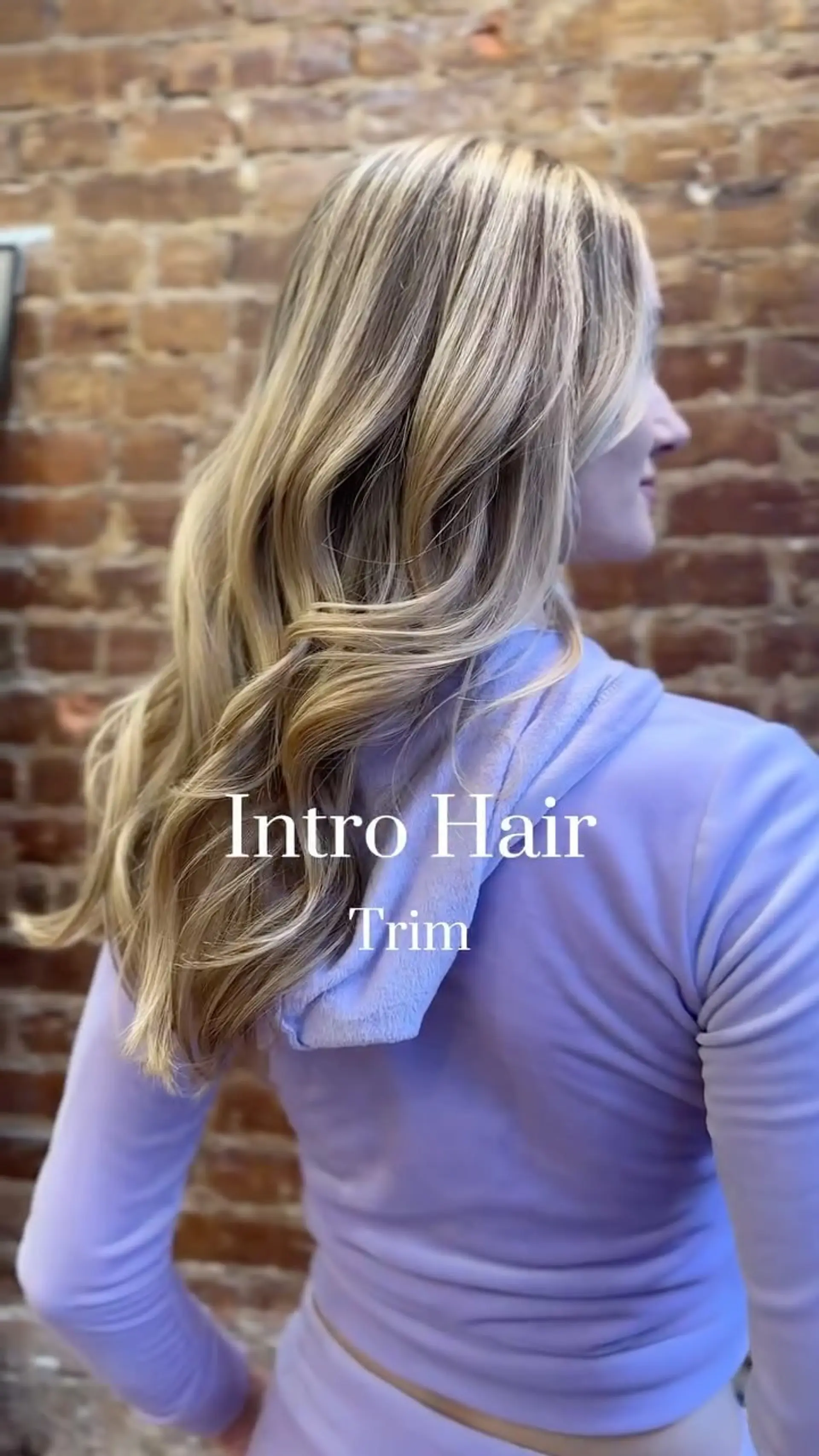 Long multi-tonal blonde hair with soft layers styled into loose, flowing beach waves. 1