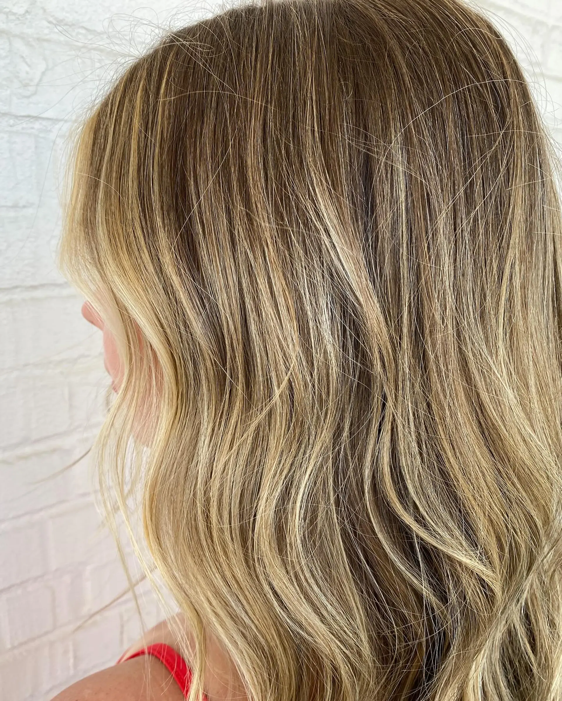 Warm, buttery blonde balayage blended seamlessly from natural roots and styled with soft dimensional waves. 1