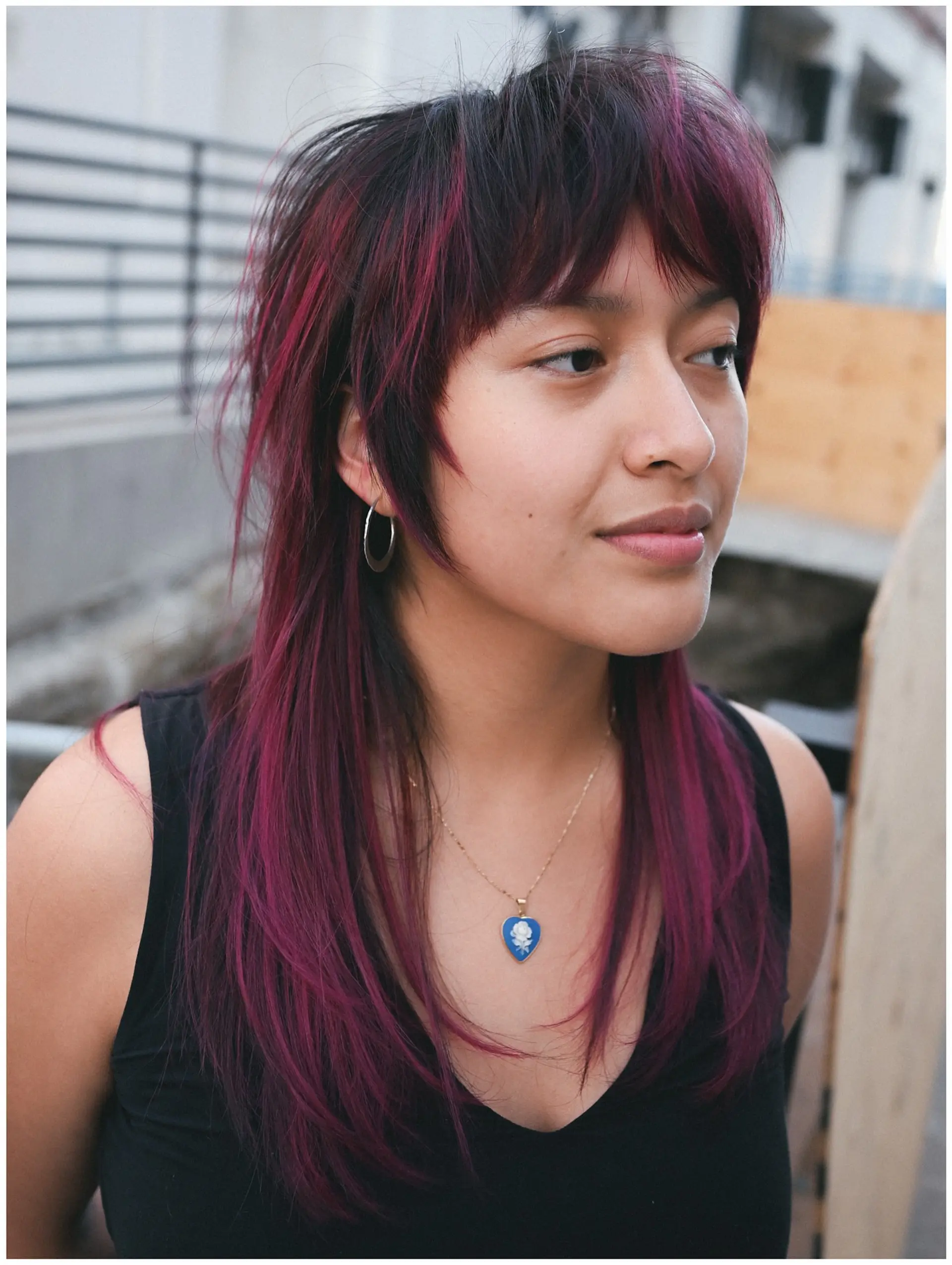 A textured shaggy mullet featuring choppy fringe bangs and vibrant magenta highlights woven through dark hair. 1
