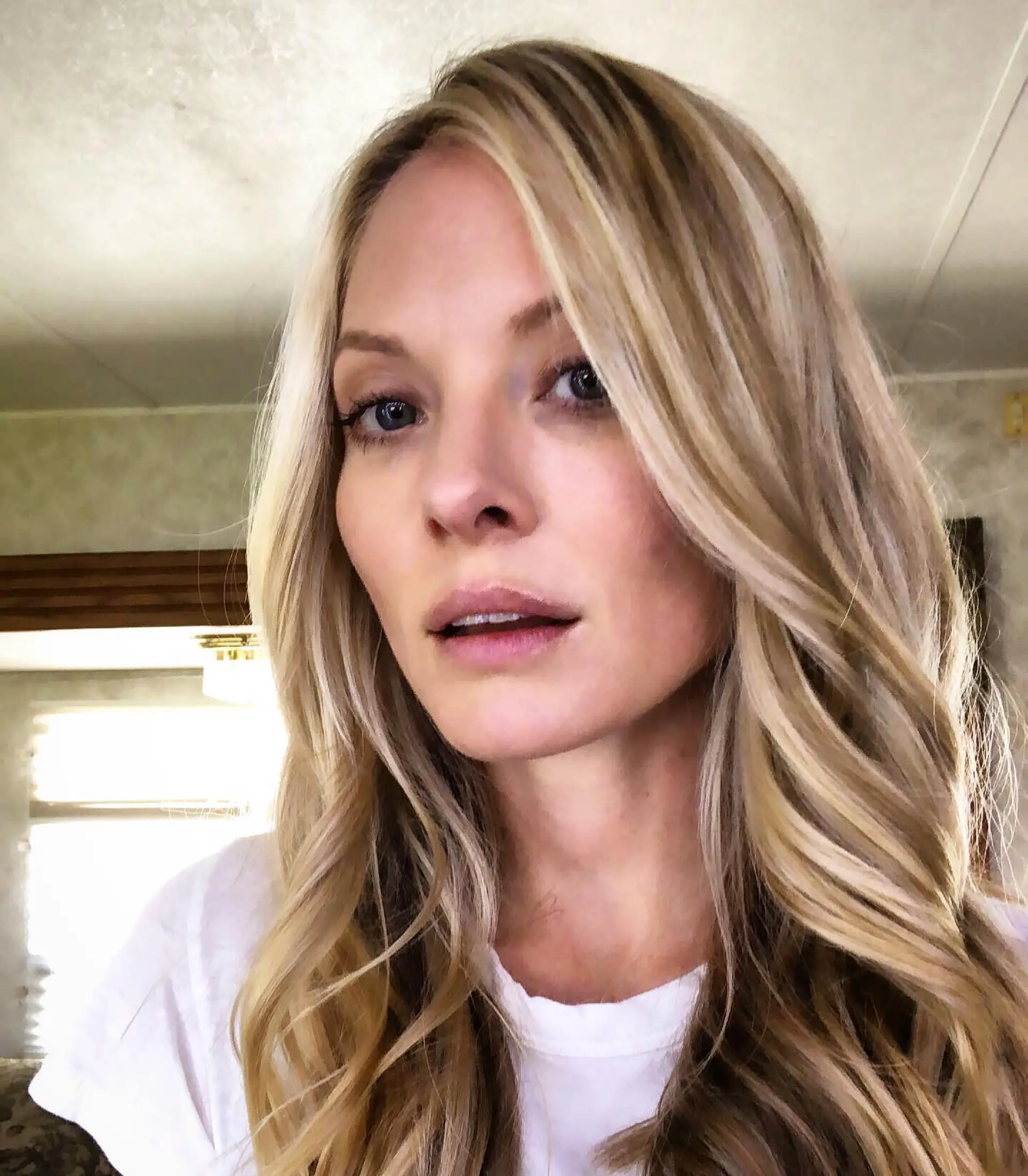 Long dimensional blonde hair styled into soft, flowing loose waves with face-framing layers. 1