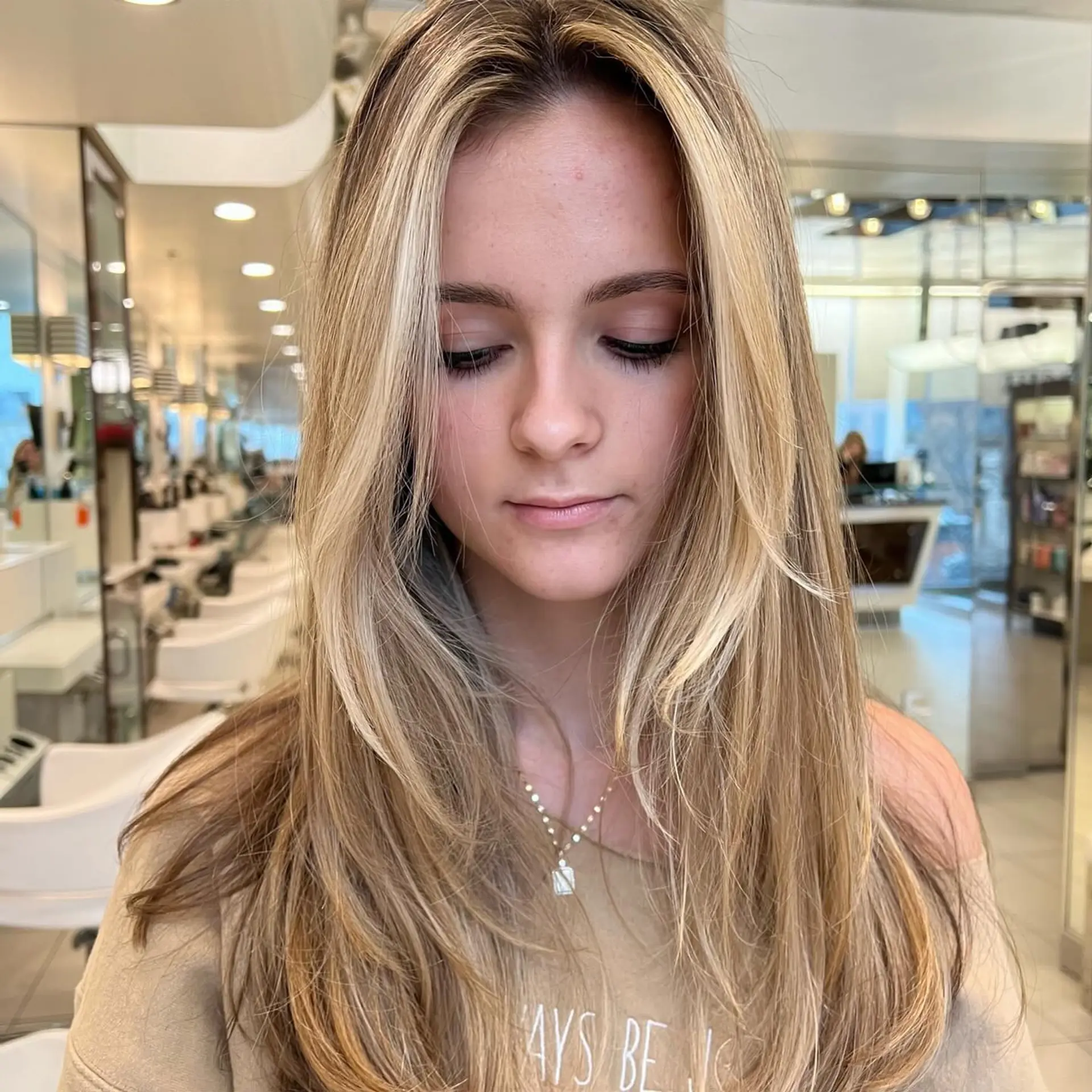 Long golden blonde hair cut with cascading face-framing layers and styled in a smooth blowout. 1