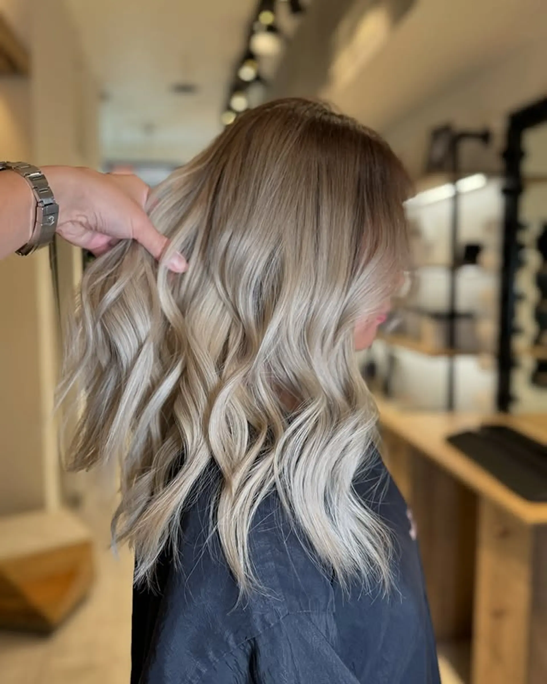 A chic medium-length hairstyle featuring bronde tones and relaxed beach waves. 1