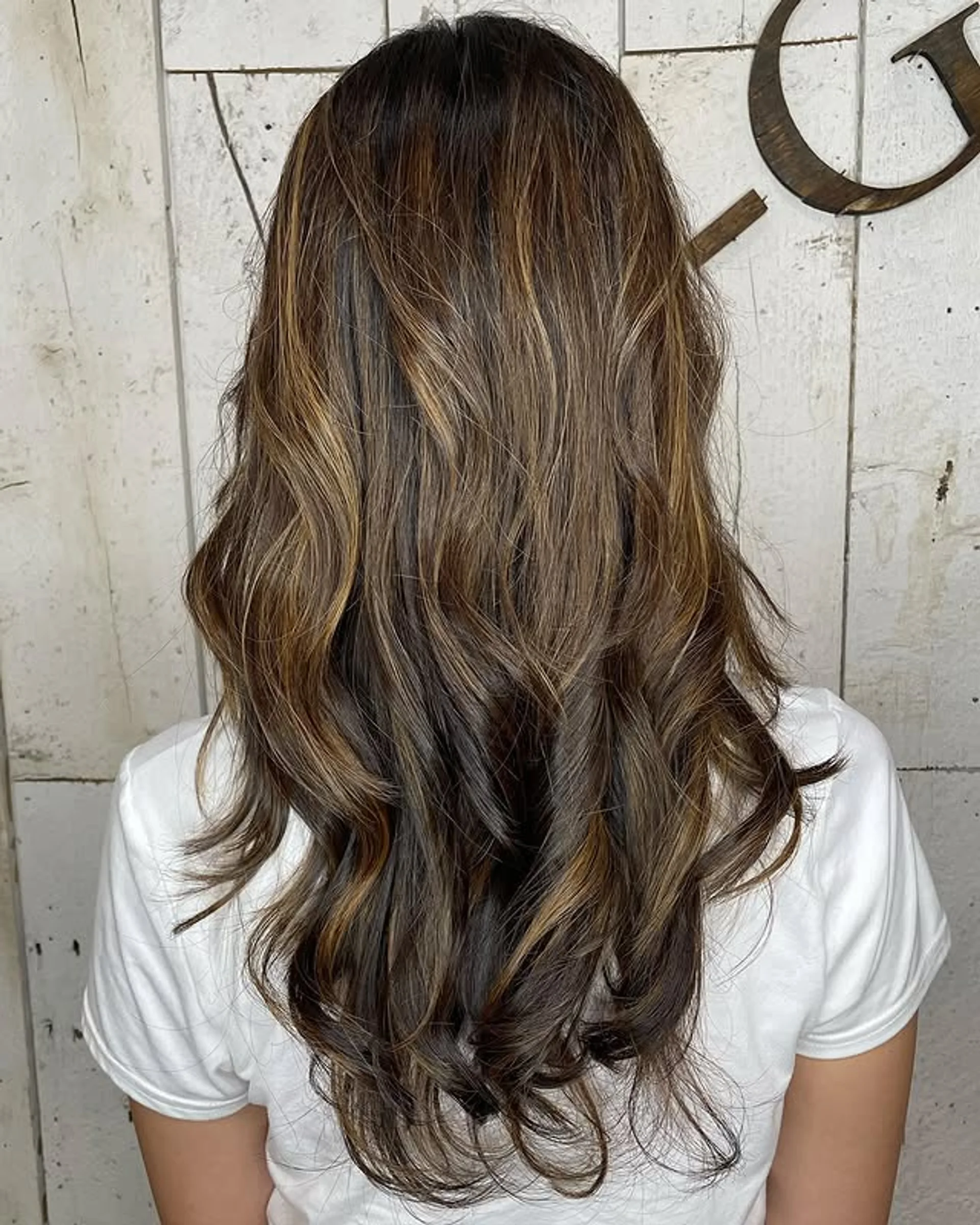 Long hair styled in soft, cascading beachy waves with a dimensional sun-kissed caramel balayage - Preview 1