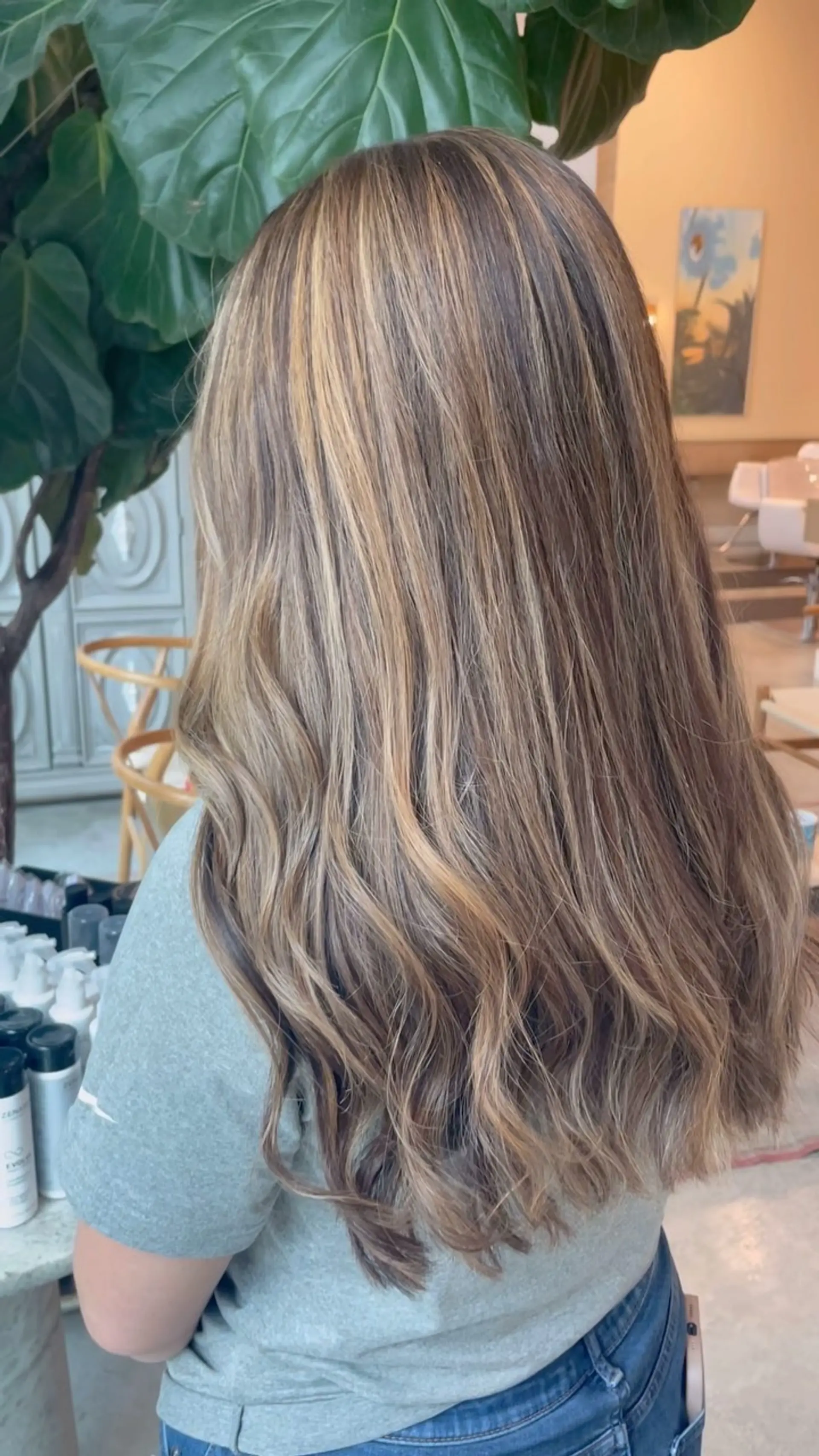 Long dimensional warm blonde hair styled with soft, cascading waves. 1