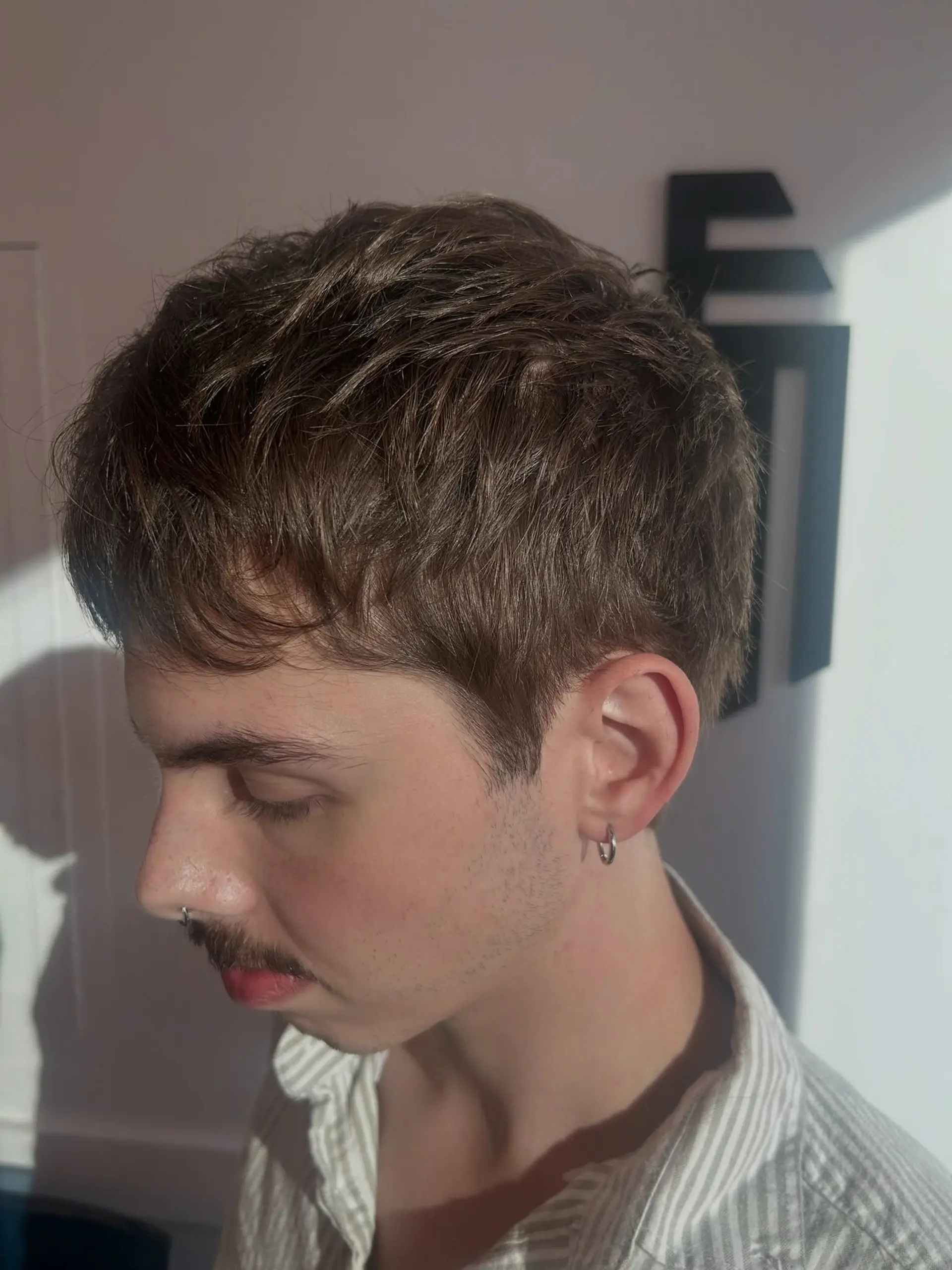 A short textured crop haircut with soft tapered sides and piecey fringe. 1