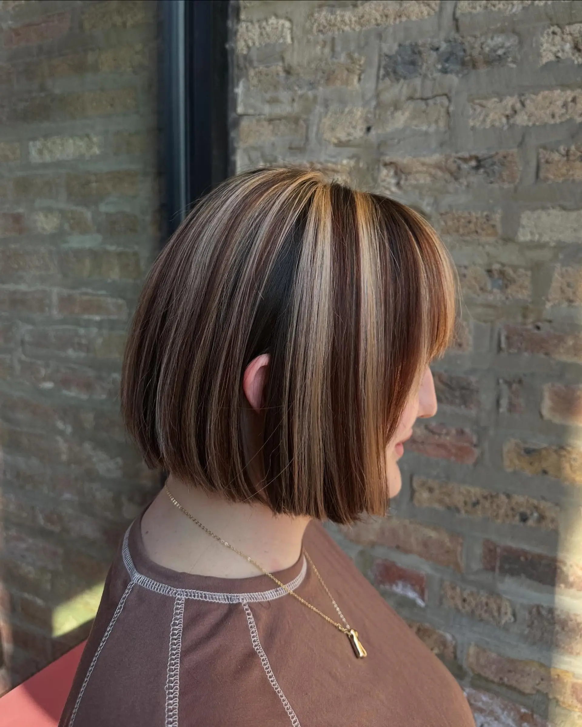 A medium-length blunt bob with ribbon highlights and face-framing bangs. 1