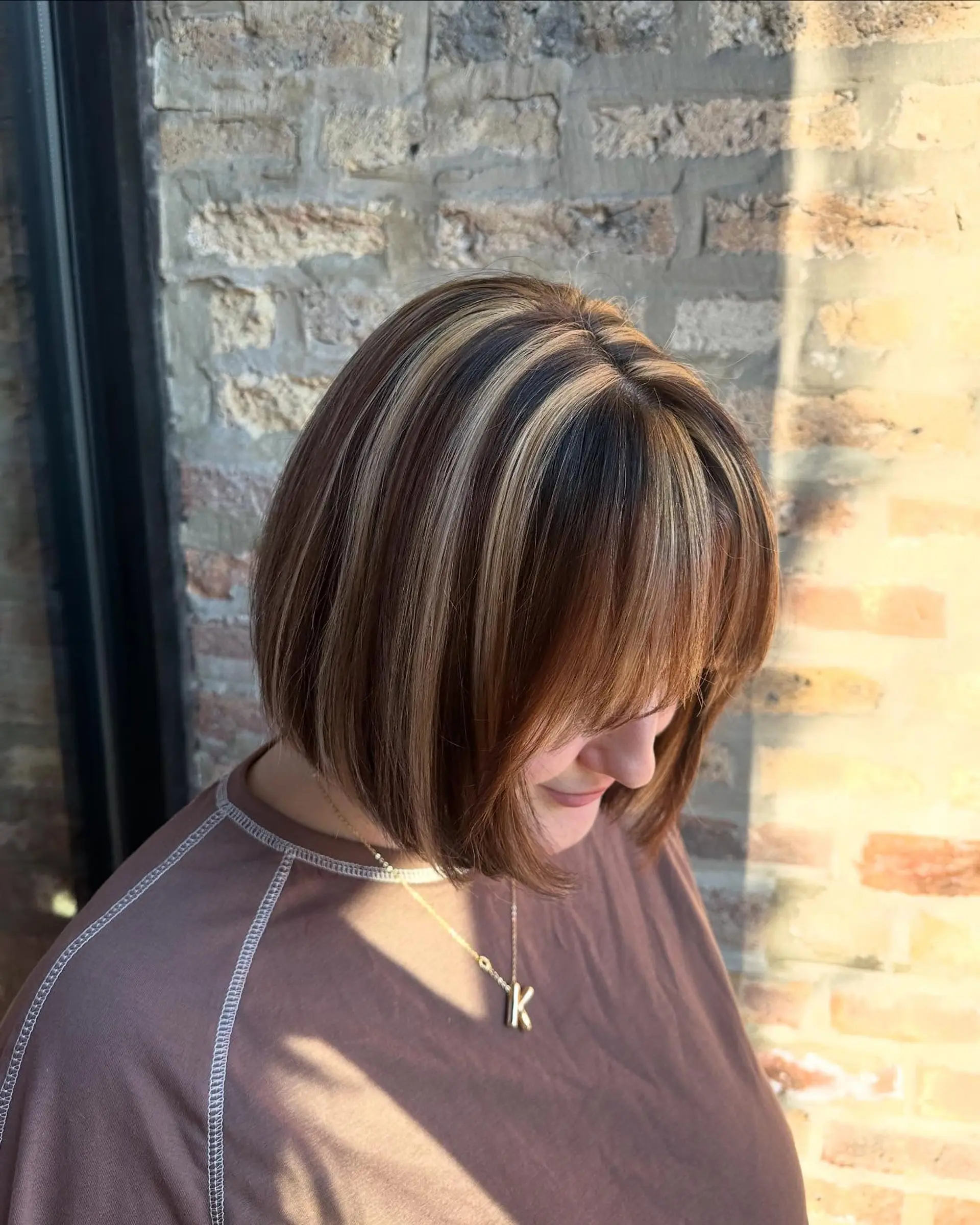 A medium-length blunt bob with ribbon highlights and face-framing bangs. 3