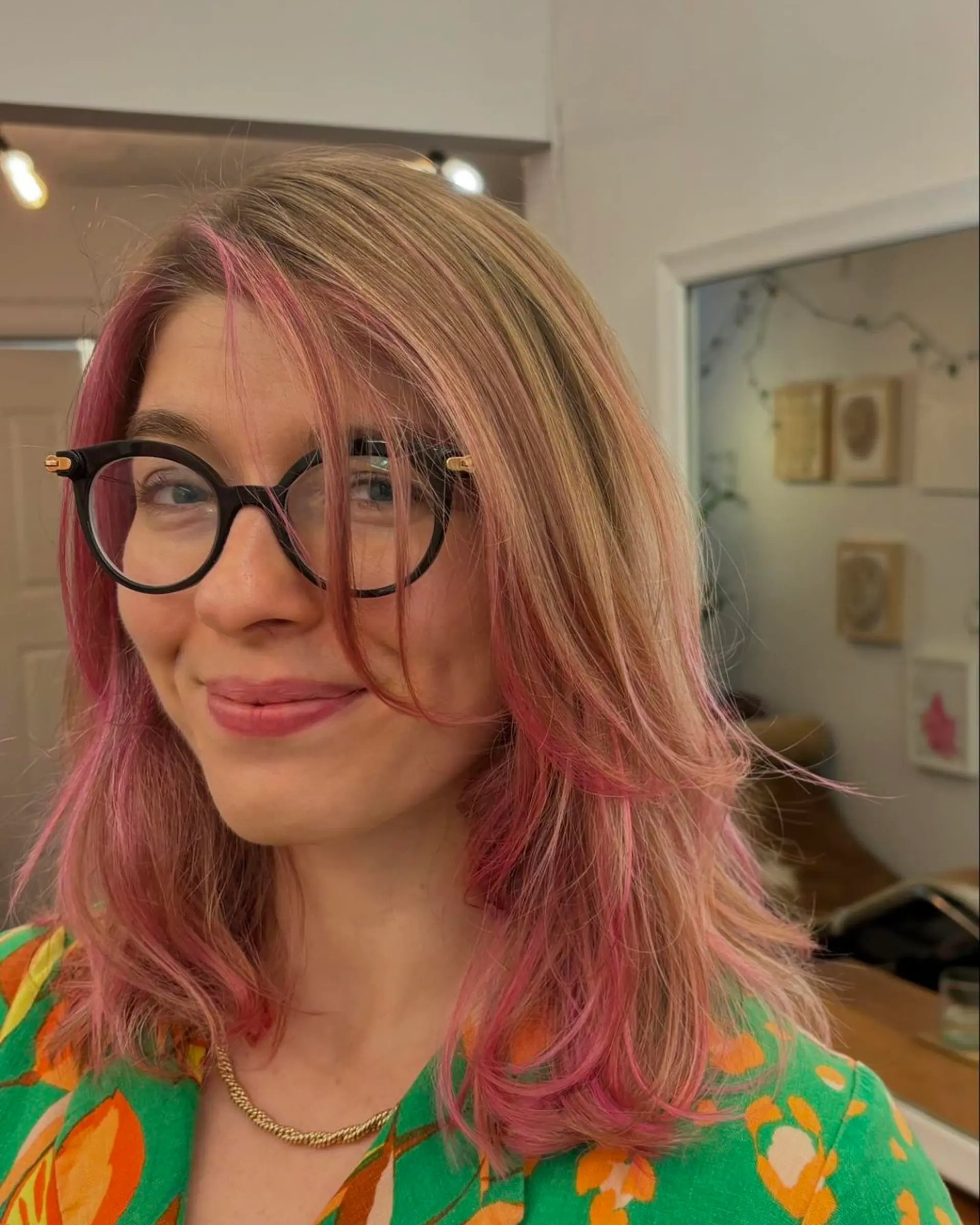 A medium-length wavy hairstyle with a blonde base and vivid pink highlights. Features face-framing layers and a side part. Cotton pink balayage 🎀 1