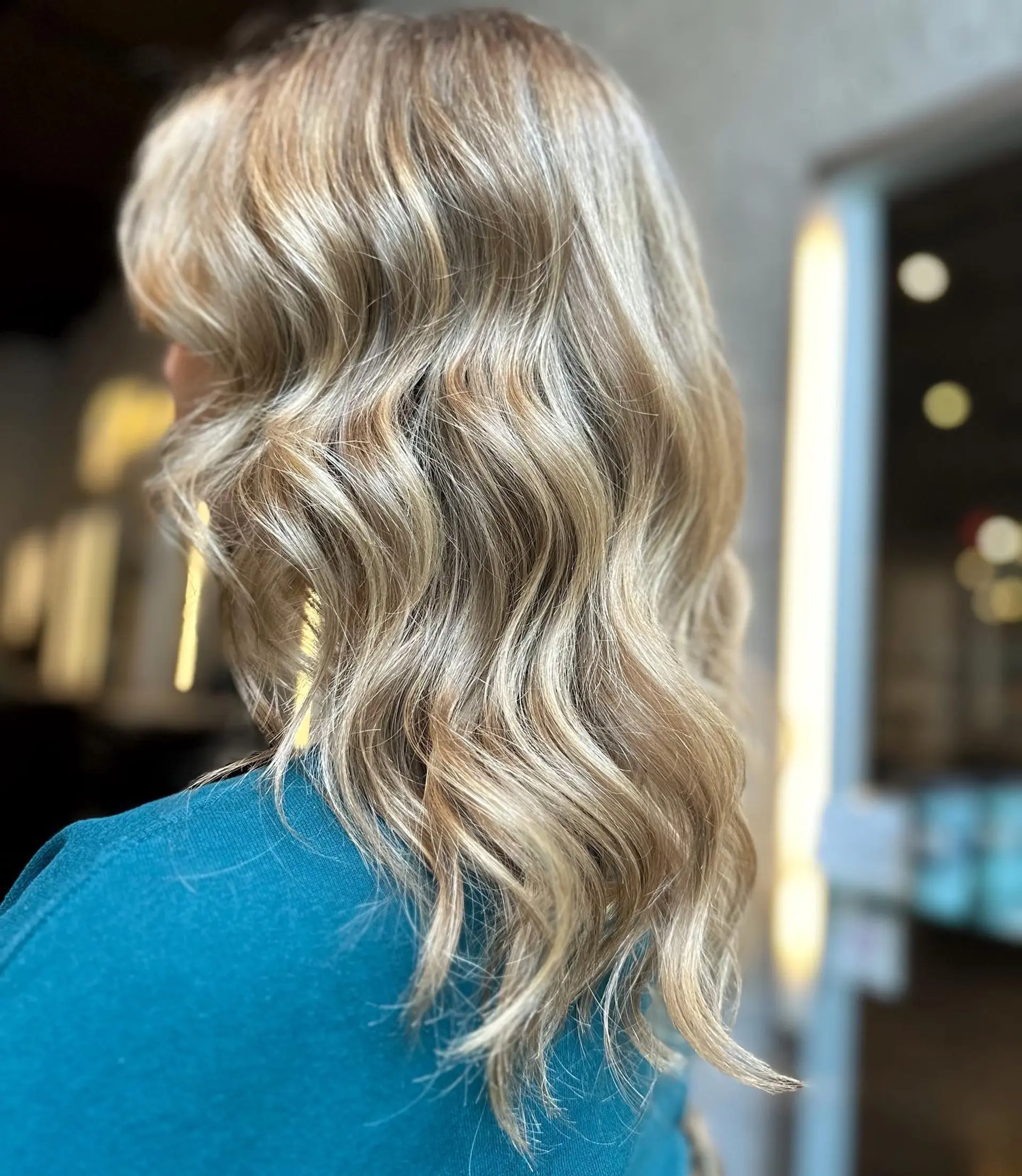 This hairstyle features medium-length wavy hair with a balayage color technique. 1