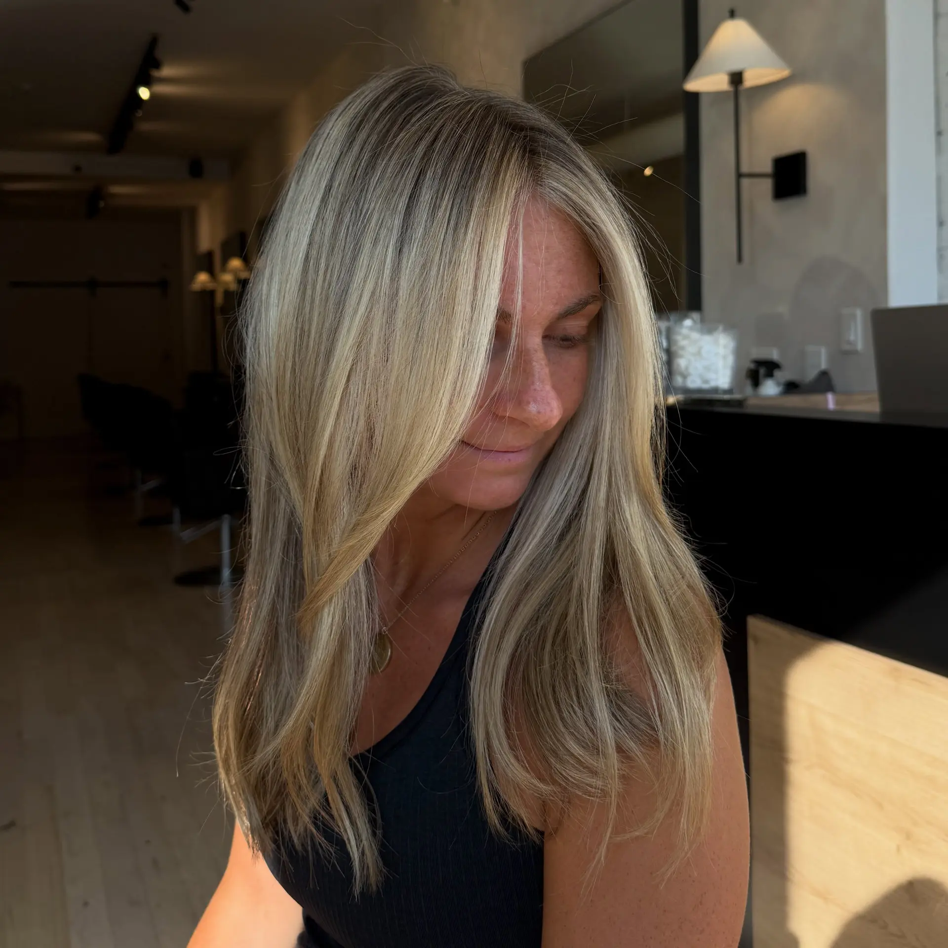 Smooth, sleek blowout with soft face-framing layers and bright dimensional blonde highlights. 1