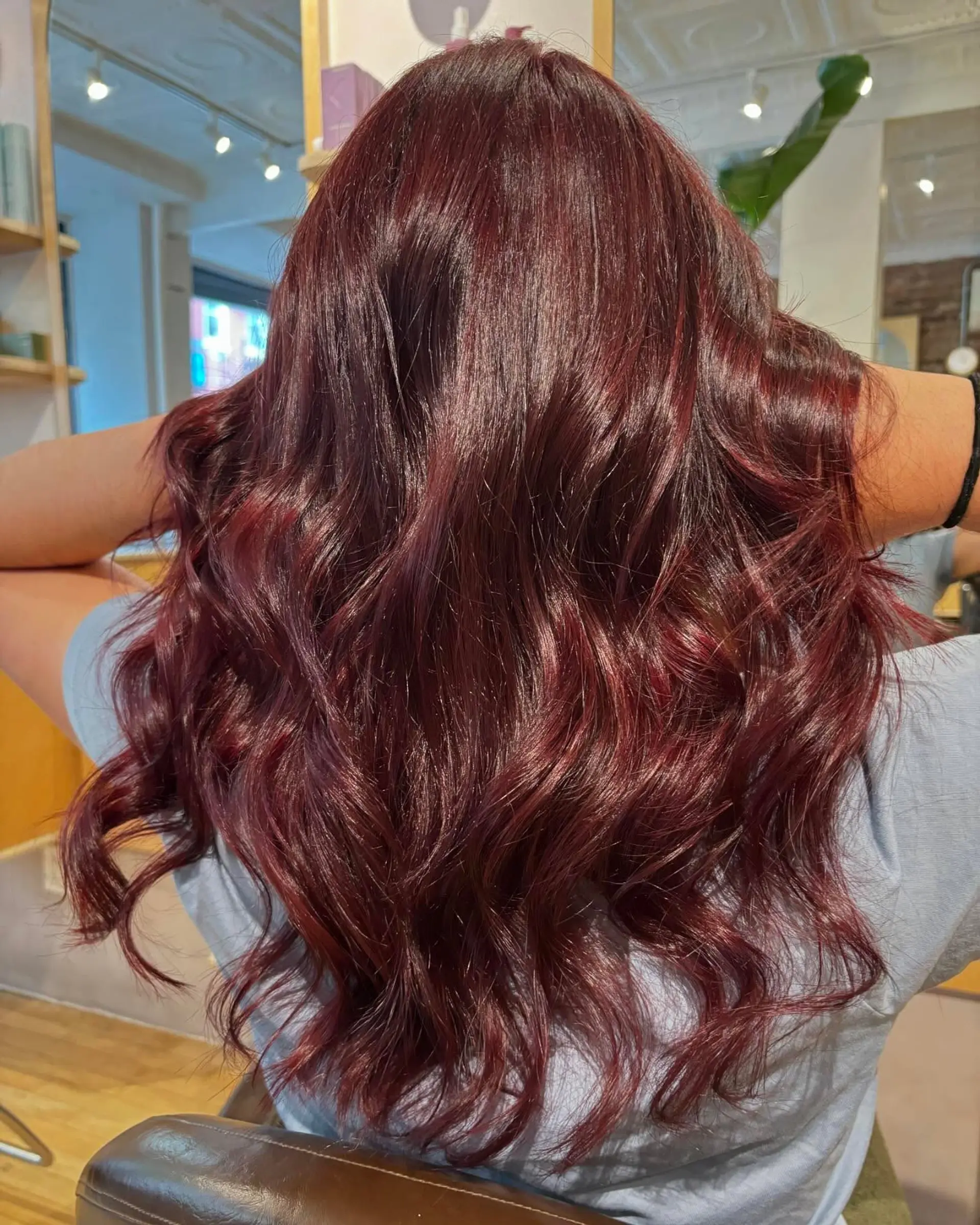 Long, lustrous deep burgundy-red hair styled in loose, voluminous waves. 1