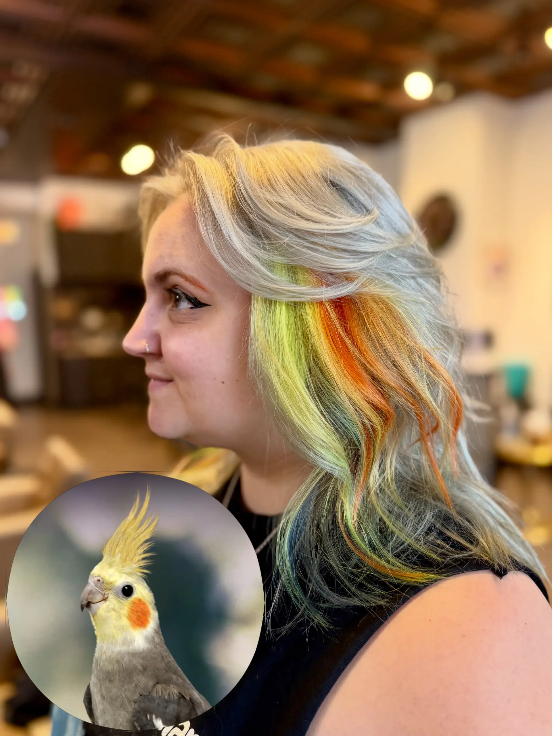 Medium-length feathered platinum blonde hair styled with bright yellow and fiery orange vivid peekaboo colors underneath. 1