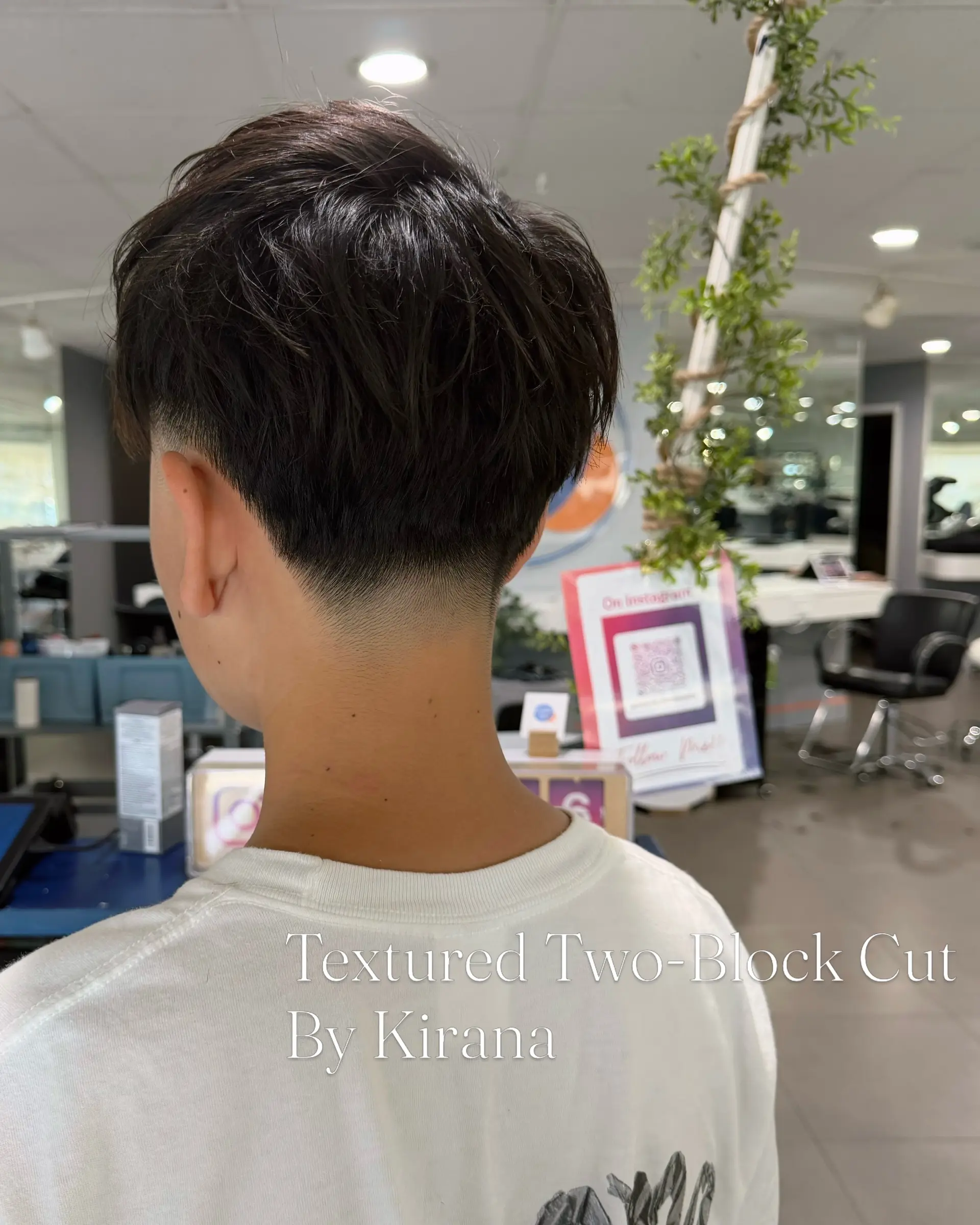 A textured two-block haircut featuring a clean taper fade at the nape and textured layers on top. 1