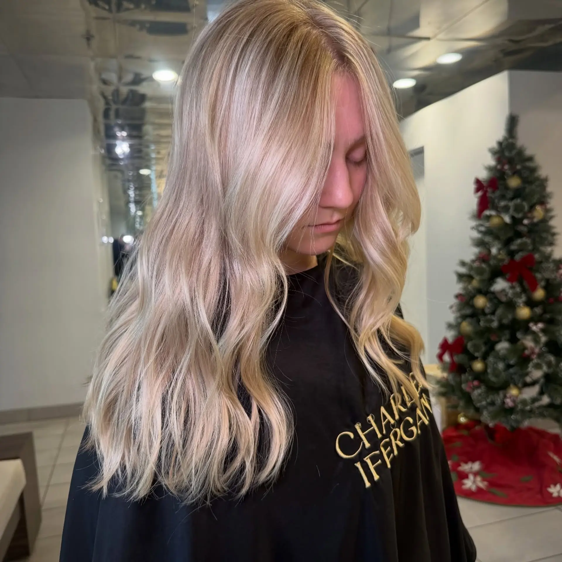 Long bright dimensional blonde hair styled in soft, loose waves cascading down the front. 1